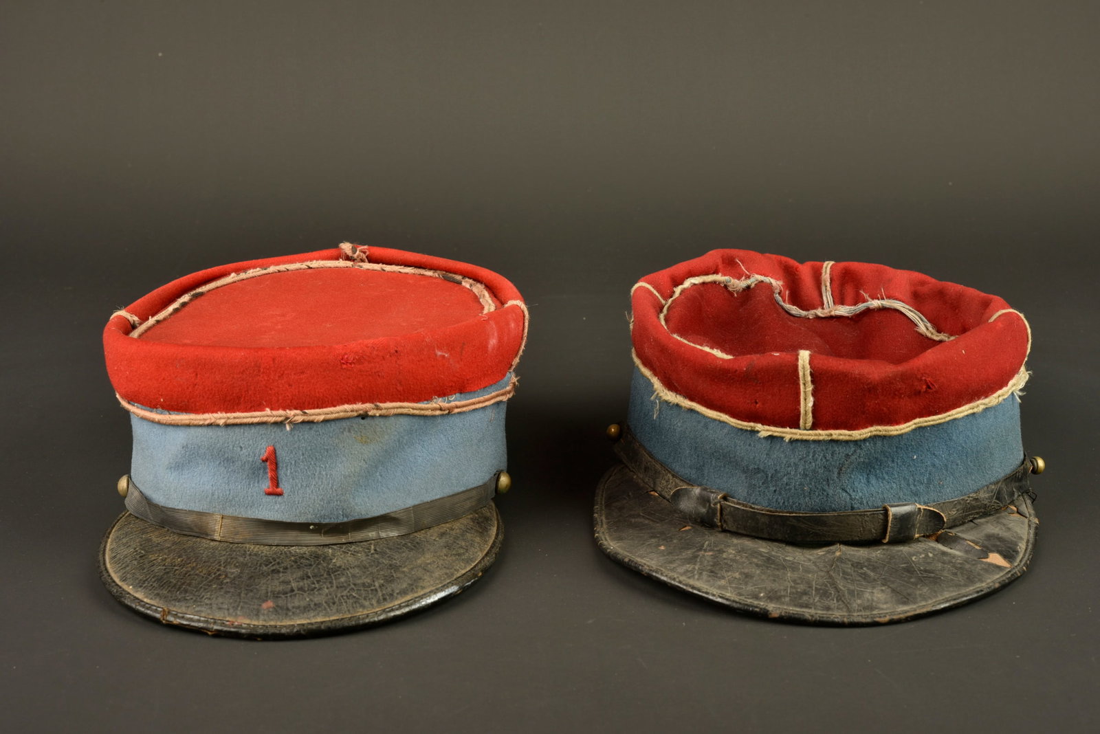 Ensemble de coiffures cavalerie. Group of cavalry headgear.: Ensemble de coiffures cavalerie. Comprenant un kepi fantaisie du 1er regiment de chasseur a cheval stationne a Chateaudun confectionne en drap de laine garance, bandeau en drap fin bleu clair.