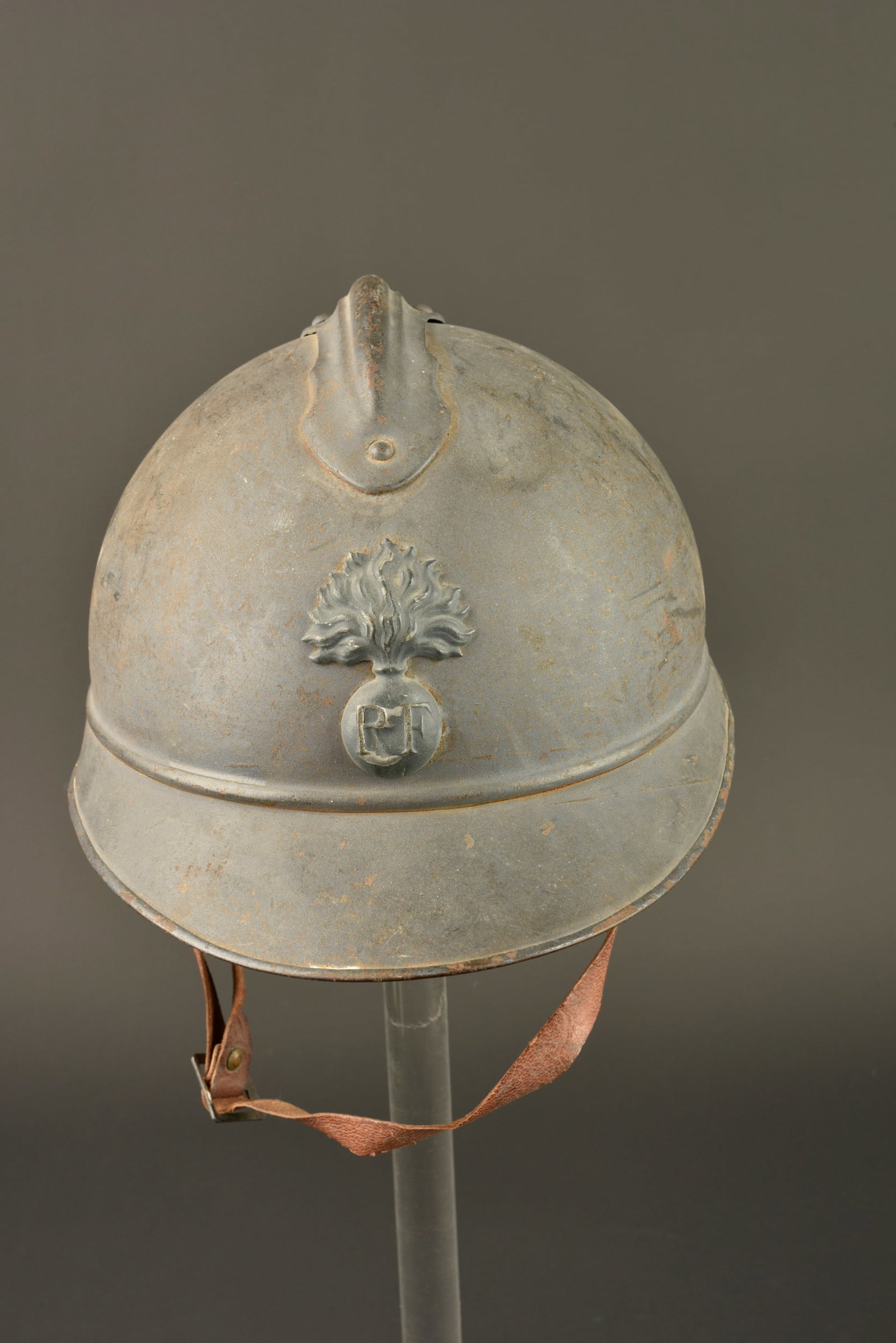 Casque Adrian 1915 infanterie. Model 1915 Adrian helmet for infantry.: Casque Adrian 1915 infanterie. Casque modele 1915 en peinture bleu horizon d usine, attribut modele 1915 de l infanterie presentant un choc. Jugulaire en cuir fauve tres souple. Coiffe du premier