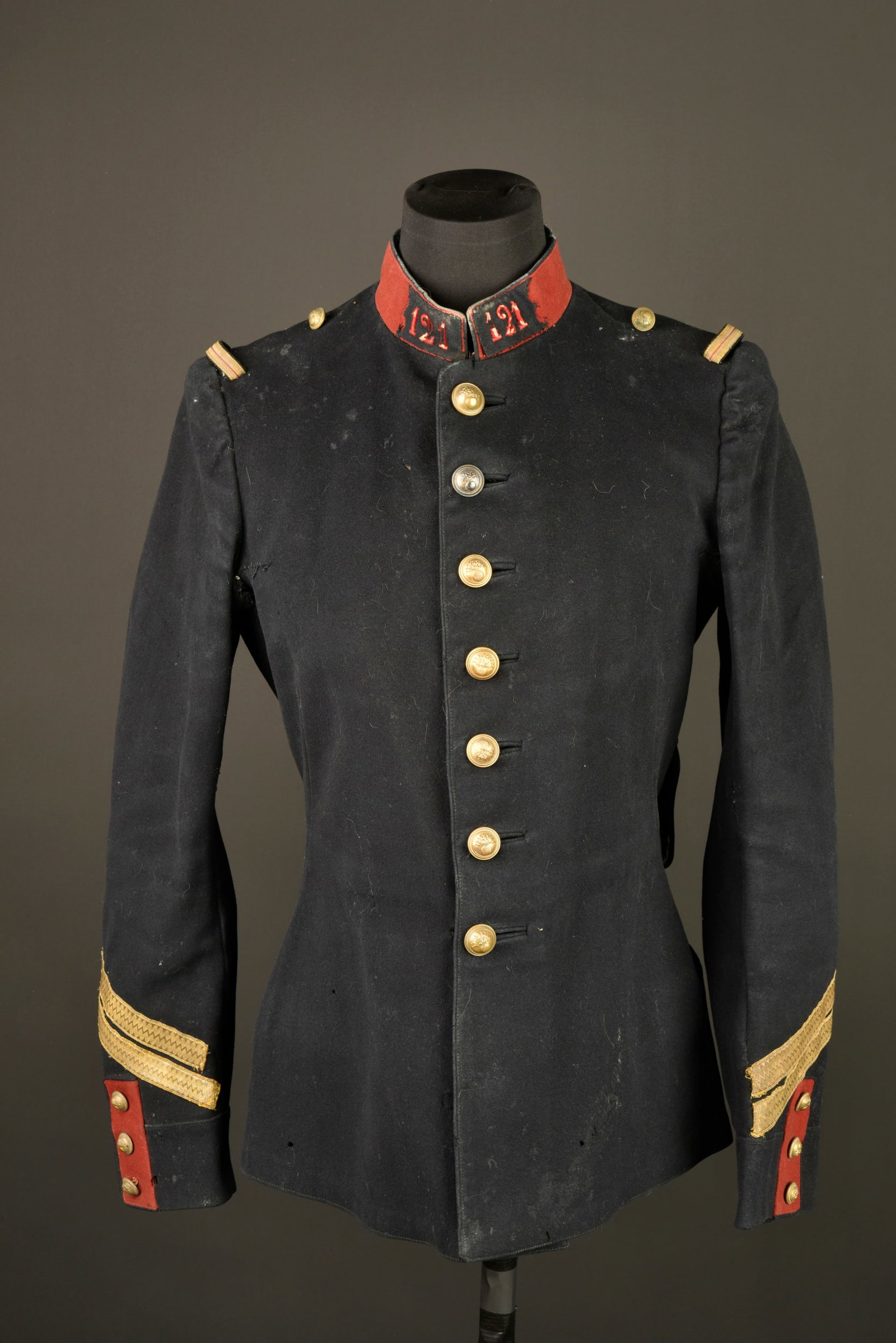 Tunique 1897 121eme RI. Model 1897 tunic of the 121st Infantry Regiment.: Tunique 1897 121eme RI. Tunique modele 1897 de fabrication tailleur d un marechal des logis de carriere. Confectionnee en drap bleu fonce et se fermant par sept boutons aux armes de l infanterie, col