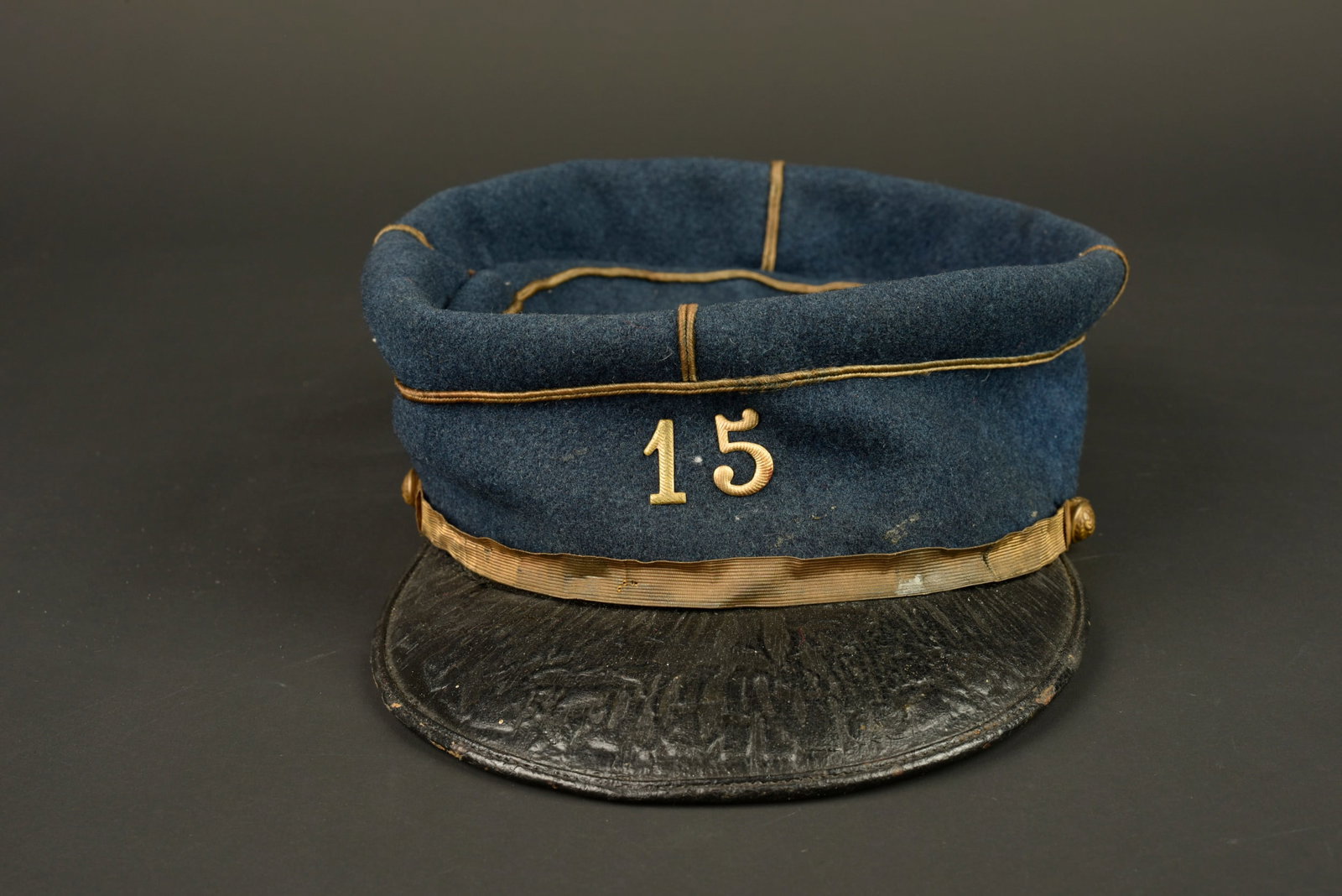 Kepi sous lieutenant 15eme SIM. Second lieutenant’s kepi of the 15th SIM.: Kepi sous lieutenant 15eme SIM. Realise en drap gris de fer bleute, grades de lieutenant cousus d origine, chiffre 15 en metal rapporte. Fausse jugulaire doree retenue par deux boutons du service de