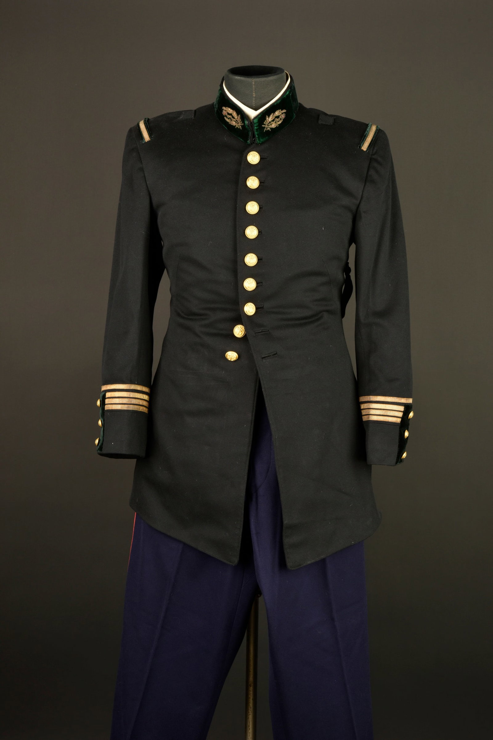 Tunique de pharmacien. Pharmacist’s tunic.: Tunique de pharmacien. Realisee en drap noir et se fermant par neuf boutons de l infanterie coloniale, pattes de col aux armes du service de sante brodees cannetille sur un drap de velours vert. Grade