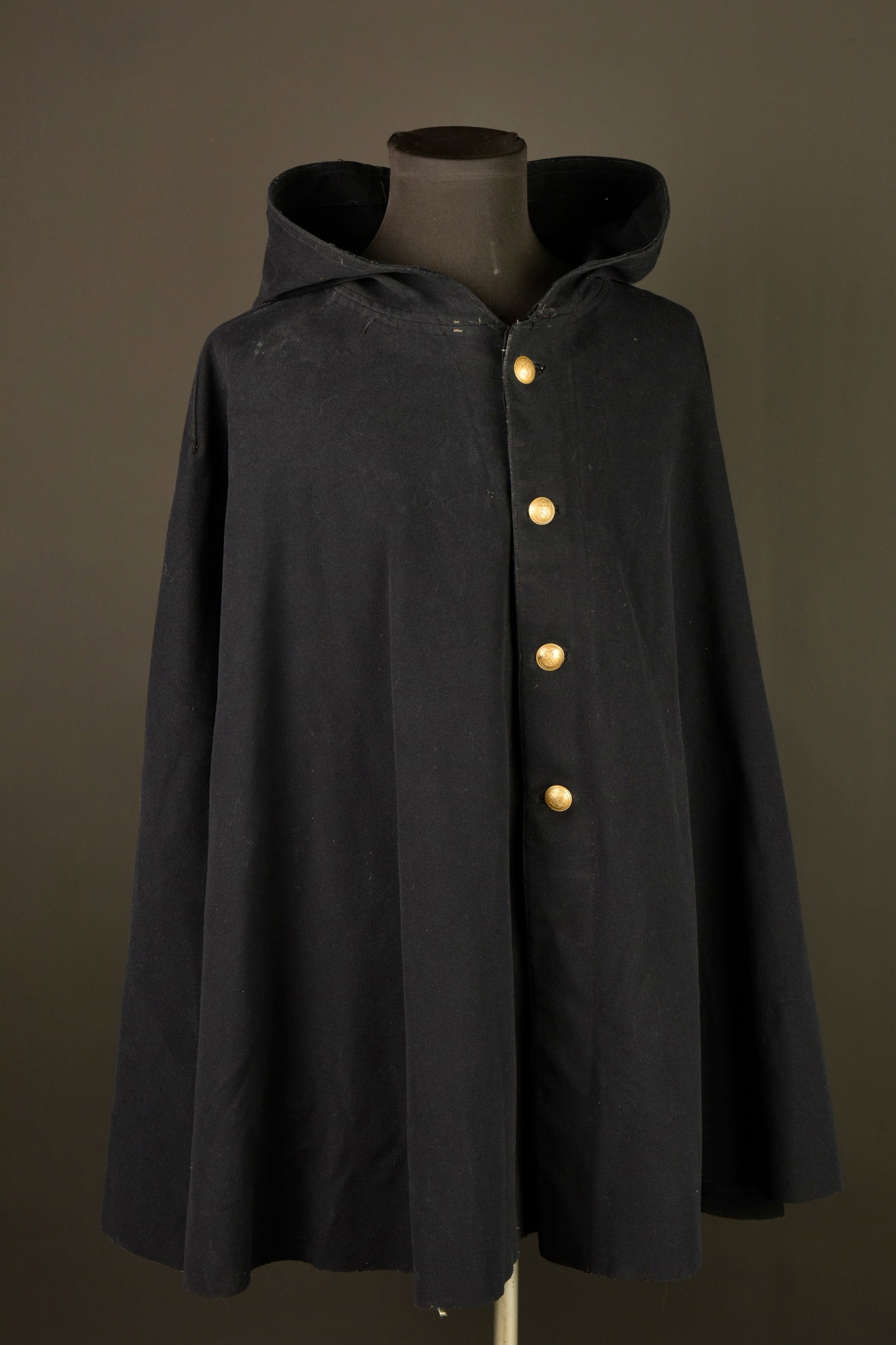 Manteau a capuchon. Hooded coat.: Manteau a capuchon. Manteau a capuchon d infanterie coloniale confectionne en laine teintee bleu fonce et se fermant a l avant par quatre boutons de l infanterie coloniale. Doublure egalement teintee.