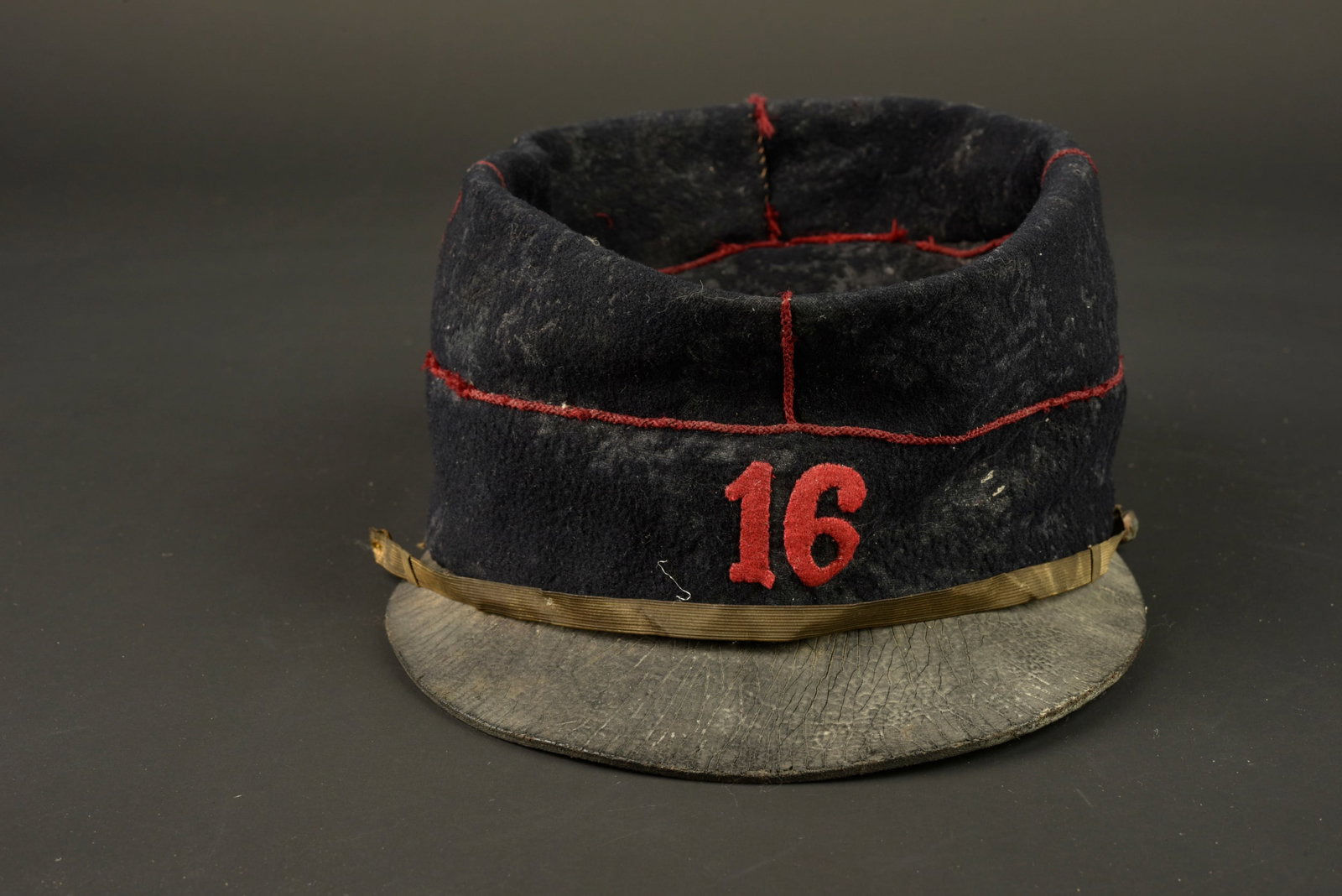 Kepi 1884 16eme d artillerie. Kepi model 1884 of the 16th Artillery Regiment.: Kepi 1884 16eme d artillerie. Kepi de type 1884 confectionne par un maitre tailleur realise en drap bleu fonce, passepoil ecarlate, chiffre cousu en drap garance. Le 16eme regiment d artillerie etait 