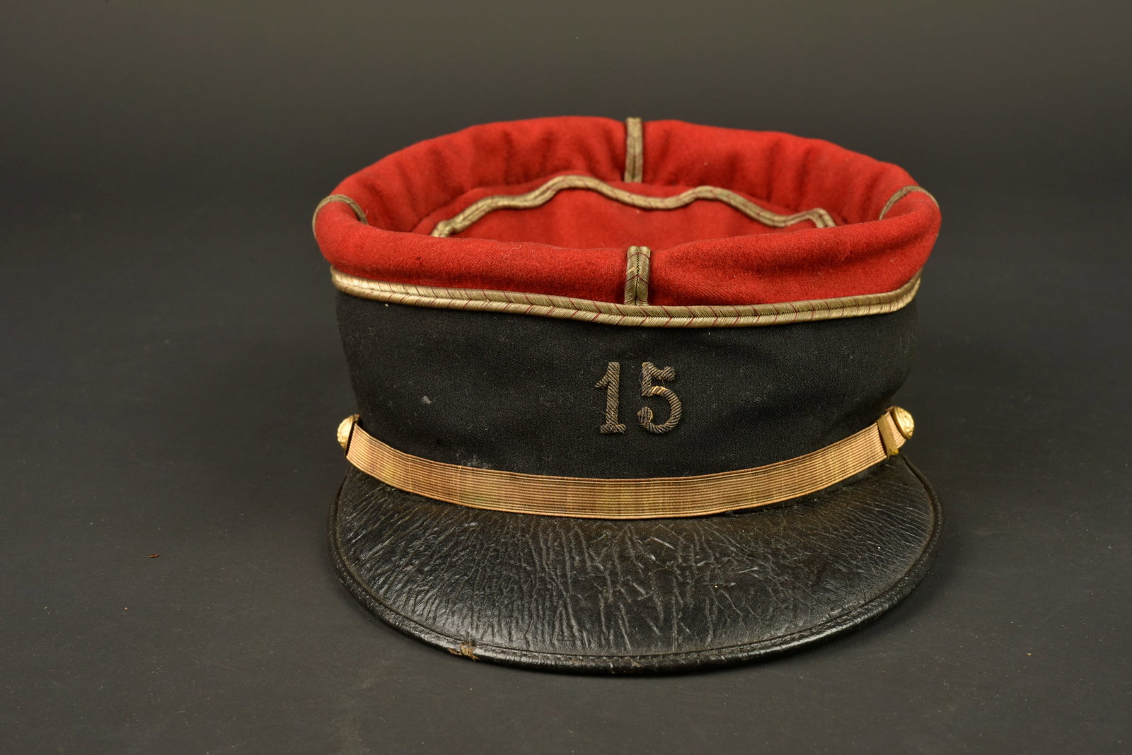 Kepi sous lieutenant 15eme SIM. Second lieutenant’s kepi of the 15th SIM.: Kepi sous lieutenant 15eme SIM. Realise en drap garance et bandeau noir, grades de lieutenant cousus d origine, chiffre 15 brode cannetille. Fausse jugulaire doree retenue par deux boutons du service 