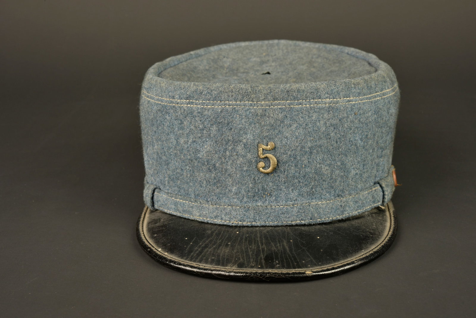 Kepi bleu horizon. Blue horizon kepi.: Kepi bleu horizon. Fabrication par un maitre tailleur en drap bleu horizon, fausse jugulaire dans le meme drap retenue par deux boutons en corozo. Visiere en cuir souple, jonc en cuir. Bandeau de suda