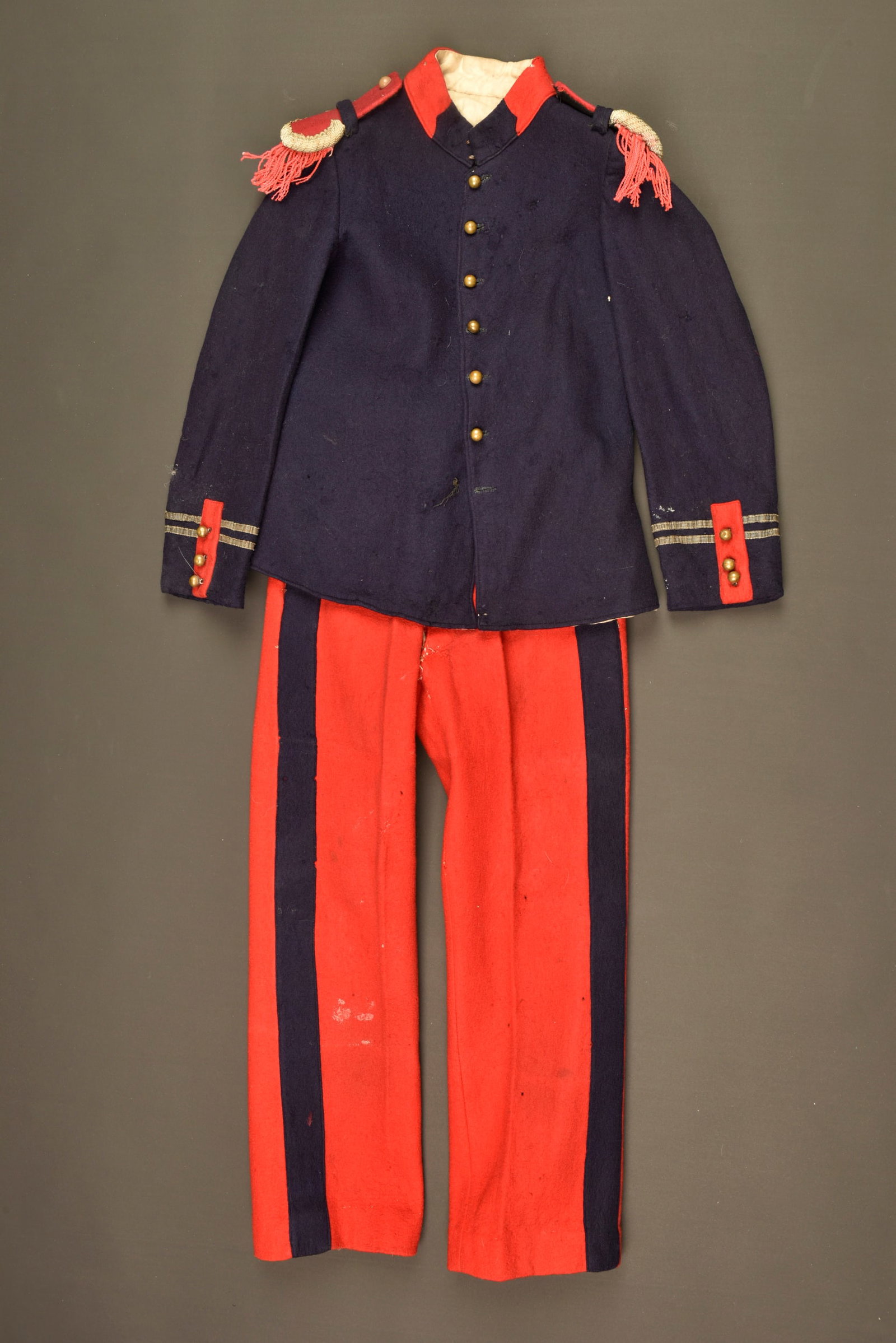 Panoplie d enfant d un lieutenant de cuirassiers. Child’s cuirassier lieutenant’s dress: Panoplie d enfant d un lieutenant de cuirassiers. Une tunique rappelant le modele 1898 en drap bleu fonce et se boutonnant par sept boutons lisses dores dont un absent Grades de lieutenant au bas de c