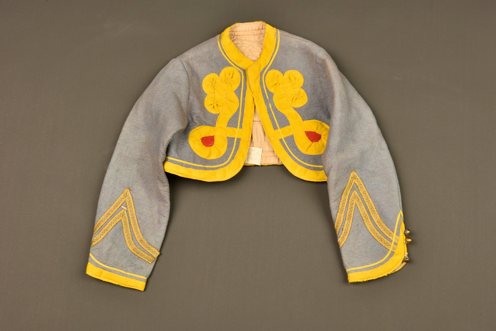 Bolero tirailleur algerien enfant. Child’s Algerian Tirailleur bolero jacket.: Bolero tirailleur algerien enfant. Confectionne en drap bleu ciel, tombeau rouge indiquant le premier regiment, tresses et parement jonquille. Grades cousus d origine, trois petit boutons grelots au b