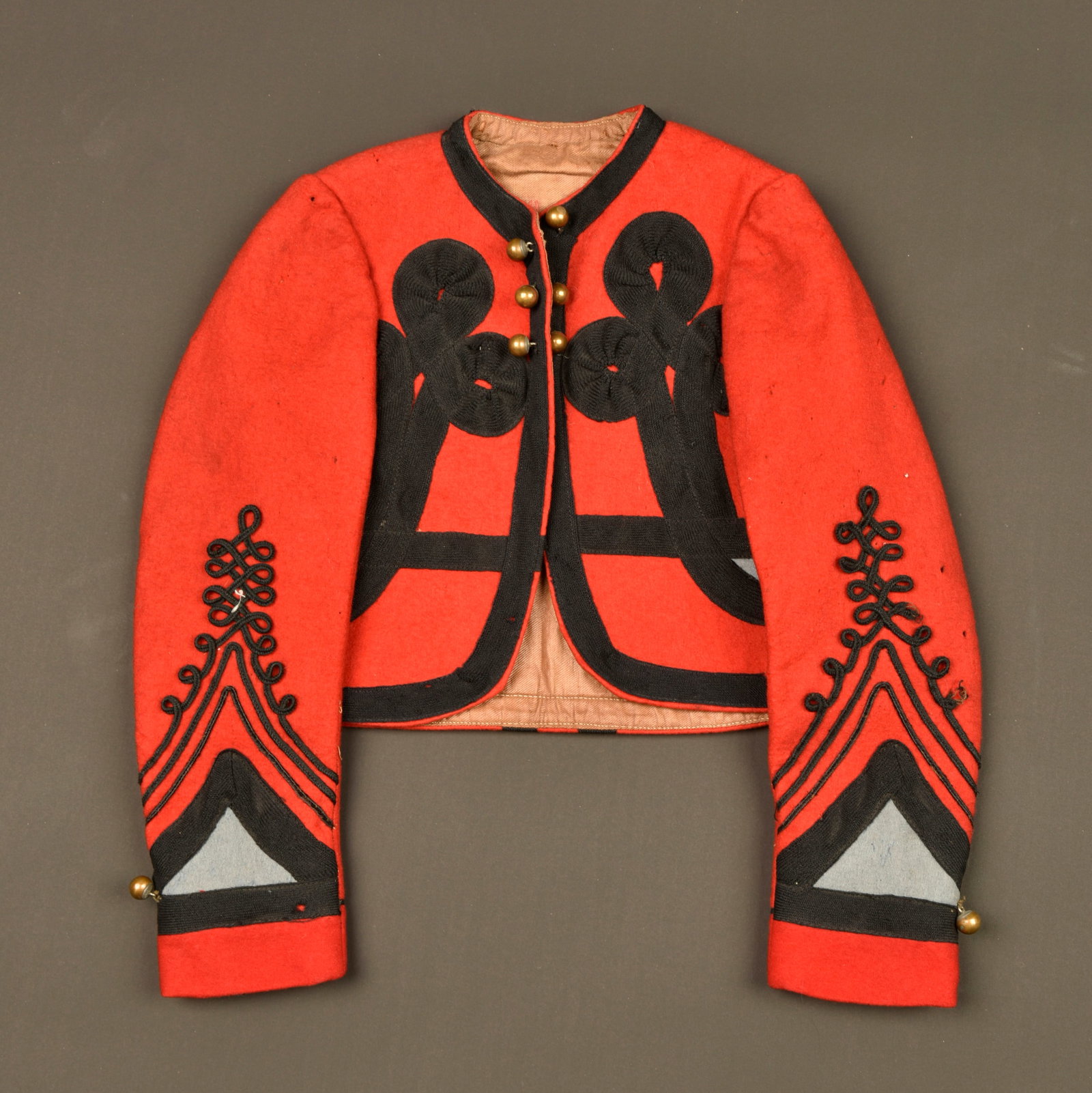 Bolero de spahis enfant. Child’s Spahi bolero jacket.: Bolero de spahis enfant. Bolero de spahis tunisien en drap de laine garance, tresses plates en coton, tombeau de couleur bleu ciel correspondant aux spahis tunisiens. Six petits boutons grelots a l av