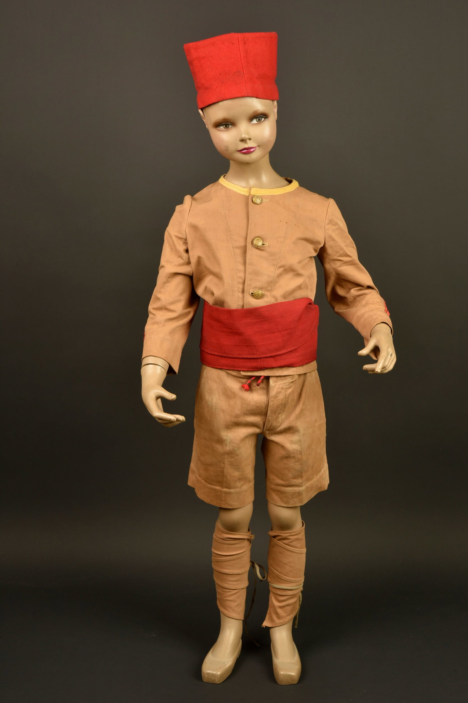 Panoplie d enfant tirailleur senegalais. Child’s Senegalese Tirailleur dress ensemble.: Panoplie d enfant tirailleur senegalais. Comprenant le paletot specifique aux tirailleurs en toile cachou a passepoil jonquille orne des boutons de l infanterie coloniale. Un short egalement en toile 