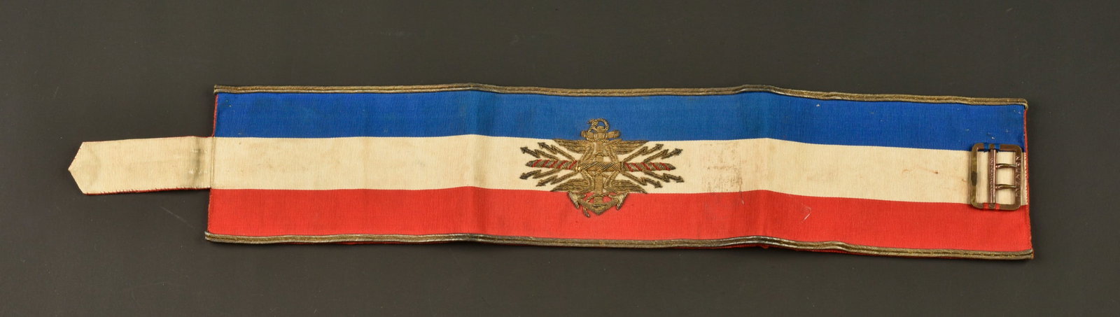 Brassard etat major corps d armee colonial. Colonial army corps headquarters armband.: Brassard etat major corps d armee colonial. Confectionne en soie tricolore, brode en son centre des foudres de l etat major entourant l ancre coloniale. Brassard borde de deux galons dores et double a