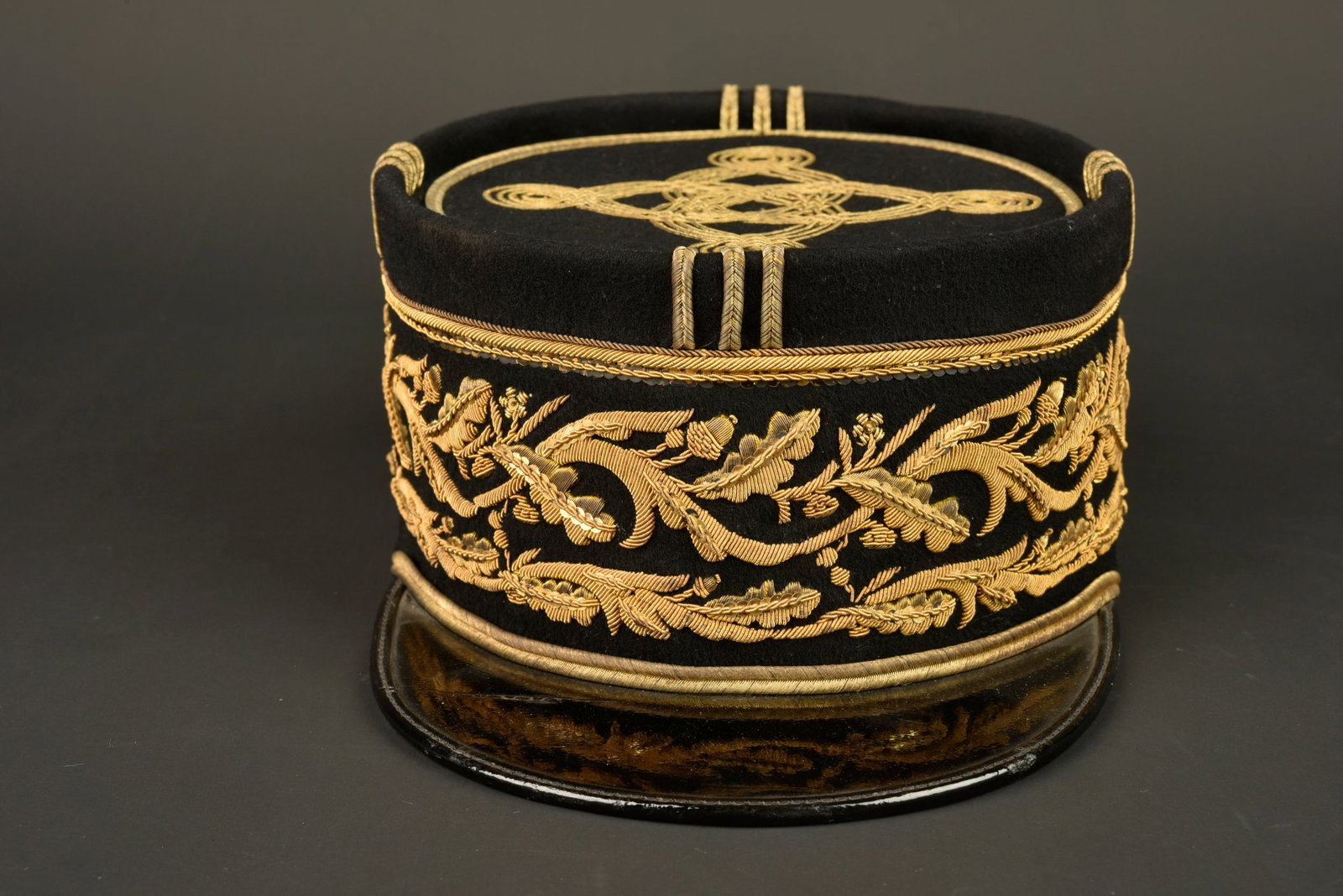 Kepi de gouverneur des colonies. Colonial governor’s kepi.: Kepi de gouverneur des colonies. Kepi en drap noir, bandeau brode en cannetille a motifs de feuilles de chene et de lauriers surmontes d un rang de paillettes, d une torsade et d une fiche soutache. L