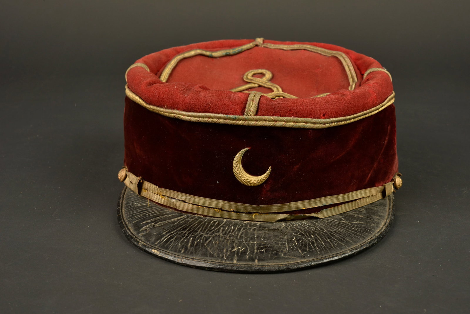 Kepi medecin troupe d Afrique. Army of Africa medical officer’s kepi.: Kepi medecin troupe d Afrique. Confectionne en drap garance, bandeau en velours cramoisi. Grades de sous lieutenant cousus d origine, croissant en metal rapporte. Fausse jugulaire accidentee retenue p