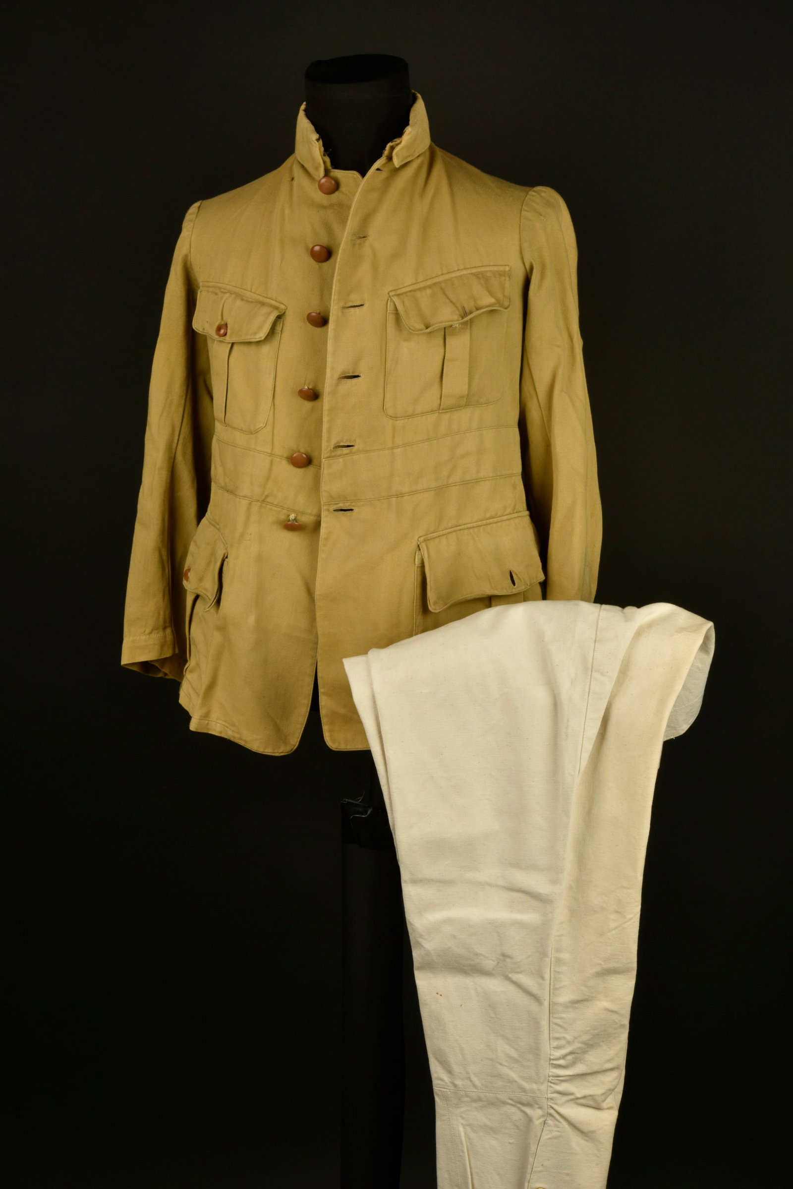 Ensemble officier troupes d Afrique. Army of Africa officer’s grouping.: Ensemble officier troupes d Afrique. Vareuse confectionnee en tissu moutarde et se fermant par six boutons, col a rabat, quatre poches a rabat. Une culotte d officier en forte toile ecrue, manchettes 