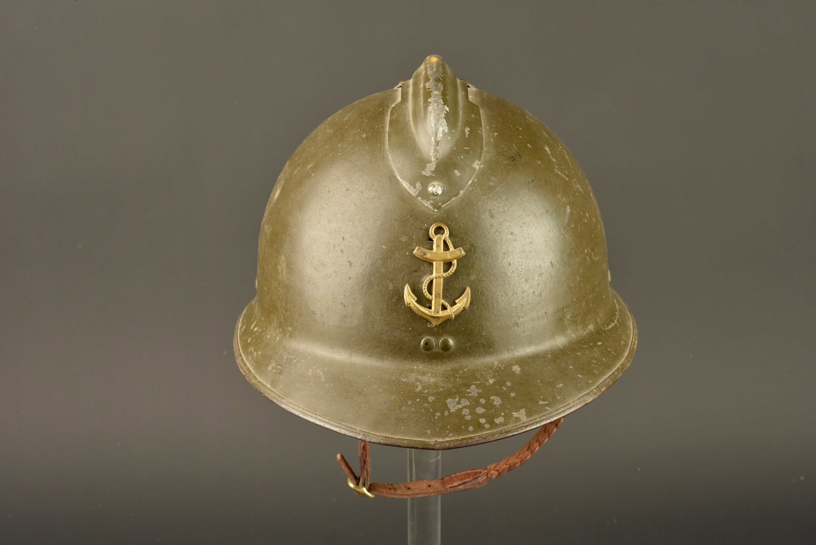Casque Adrian 1926 infanterie coloniale. Adrian helmet, 1926 pattern, colonial infantry.: Casque Adrian 1926 infanterie coloniale. Casque modele 1926 en peinture verte, attribut en laiton representant l ancre coloniale et destinee au modele 1931. L attache superieure de l insigne est accid