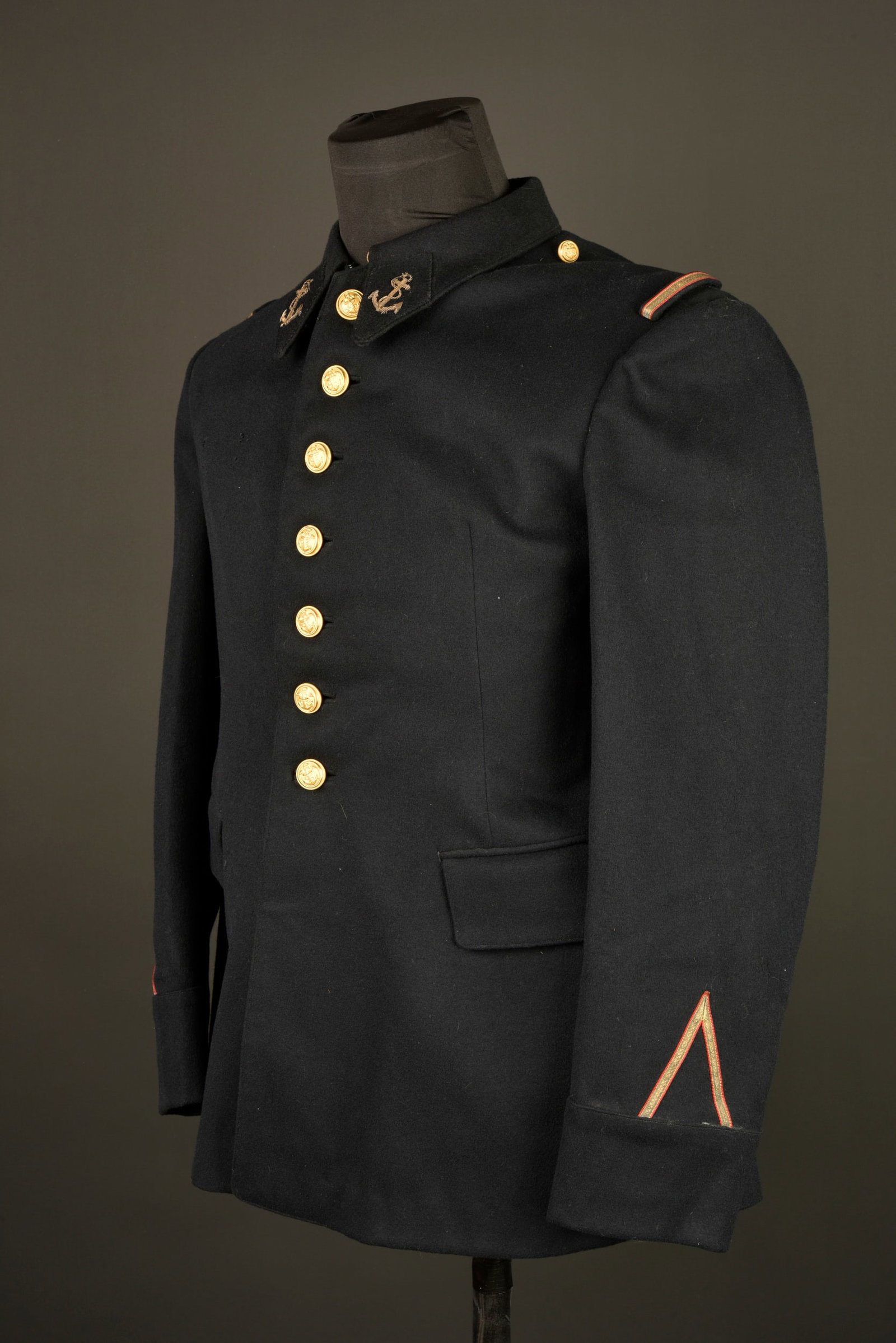 Tunique infanterie coloniale. Colonial infantry tunic.: Tunique infanterie coloniale. Confectionnee en drap noir, se fermant par sept boutons aux armes de l infanterie coloniale. Pattes de col de type aiglon avec ancre brodee en cannetille, grades aux manc