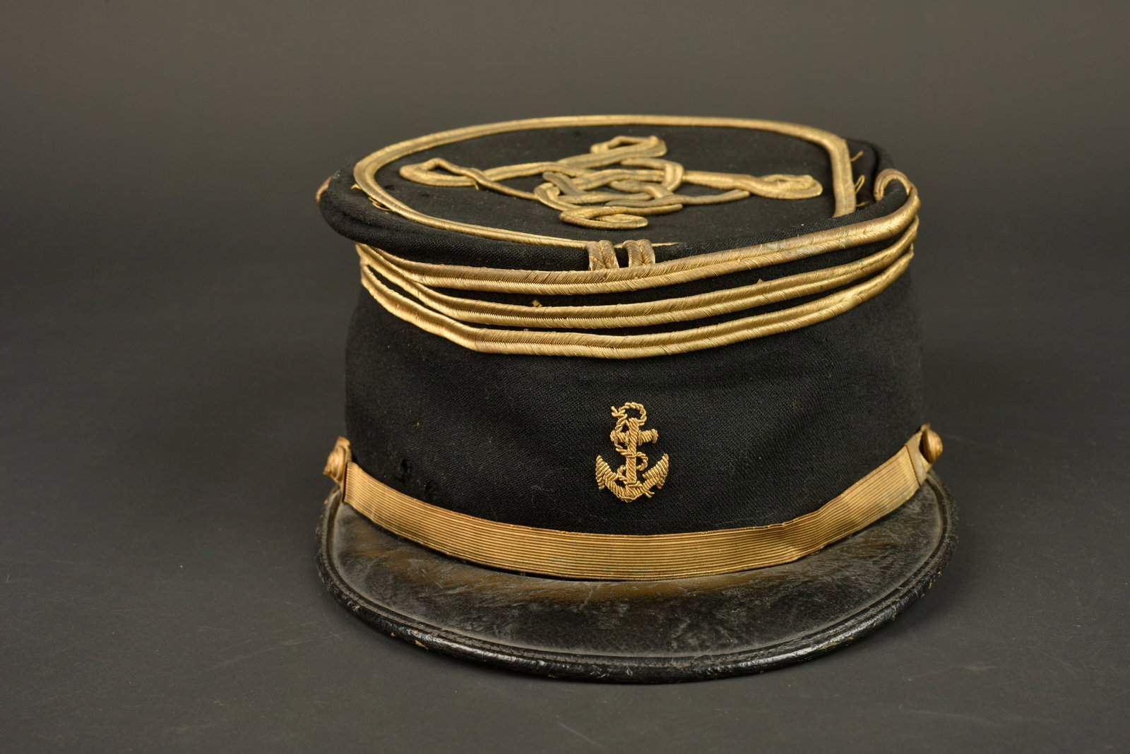 Kepi de capitaine infanterie coloniale. Colonial infantry captain’s kepi.: Kepi de capitaine infanterie coloniale. Confectionne en drap noir, grades de capitaine cousus d origine, ancre brodee en cannetille. Fausse jugulaire doree retenue par deux boutons de l infanterie col