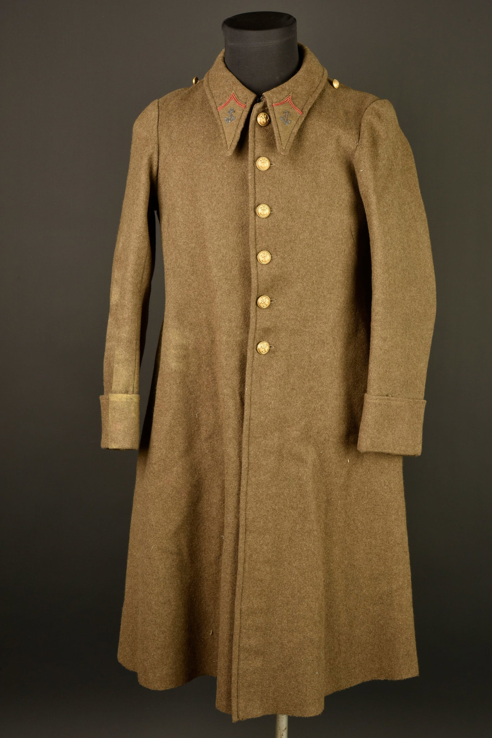 Manteau infanterie coloniale. Colonial infantry greatcoat.: Manteau infanterie coloniale. Manteau en drap kaki se fermant par six boutons aux armes de l infanterie coloniale, pattes de col de type aiglon avec ancre brodee cannetille. Doublure en coton ecru ind