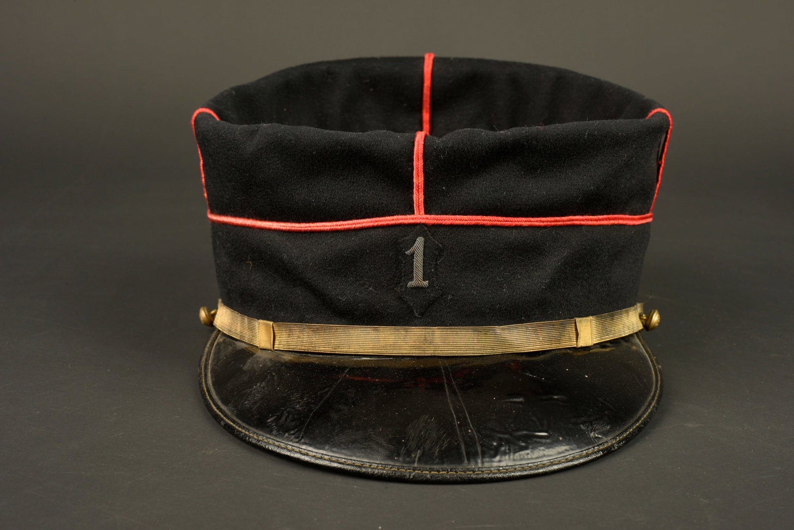 Kepi 1er RIC. 1st Colonial Infantry Regiment (1er RIC) kepi.: Kepi 1er RIC. Confectionne en drap de laine bleu fonce, passepoil ecarlate, chiffre brode cannetille sur une petite piece de drap. Fausse jugulaire doree retenue par deux boutons de l infanterie colon