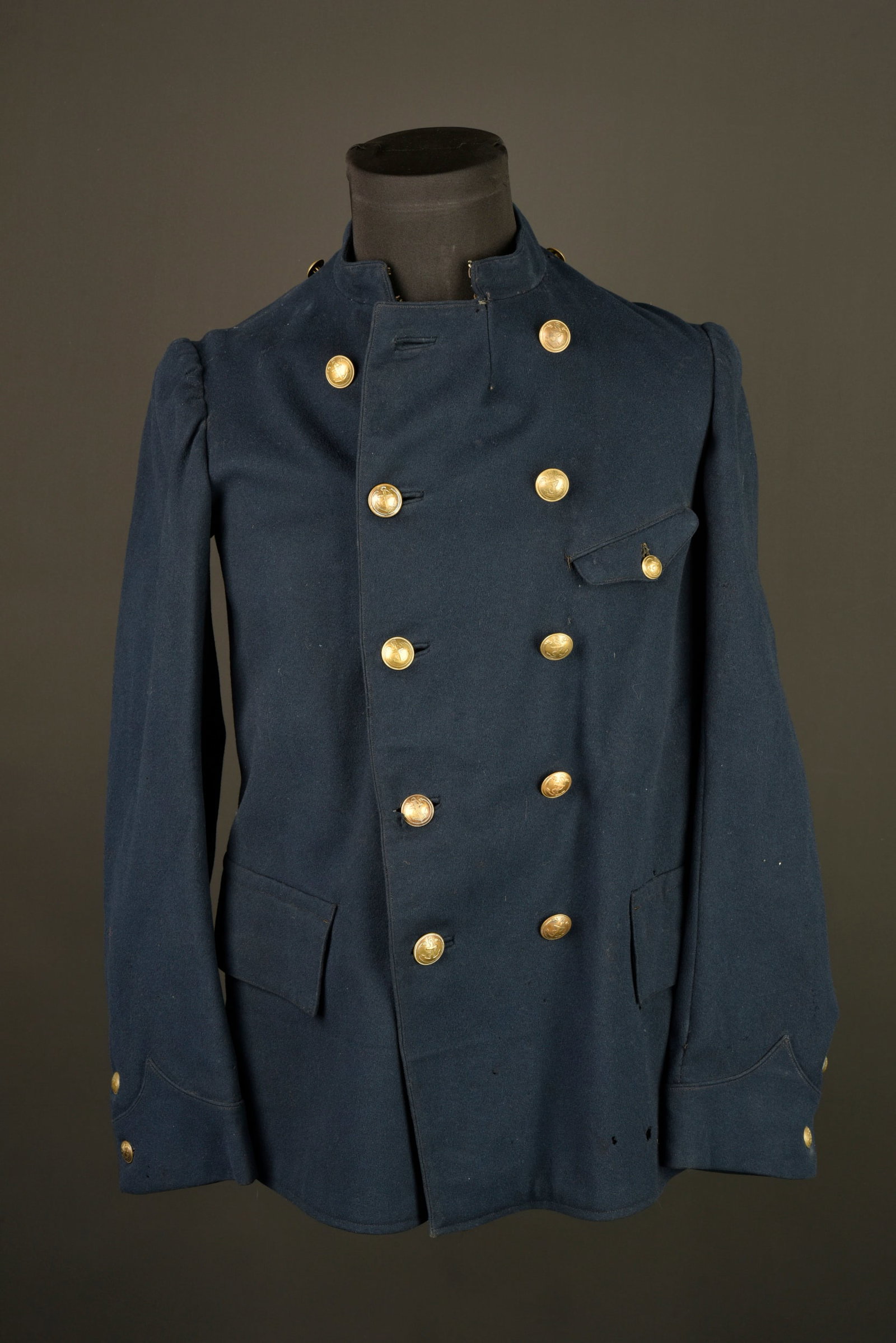 Paletot colonial. Colonial greatcoat.: Paletot colonial. Fabrication tailleur confectionne en drap bleu fonce d officier et se fermant par deux rangees de cinq boutons aux armes de la coloniale. Une poche de poitrine oblique, deux poches i