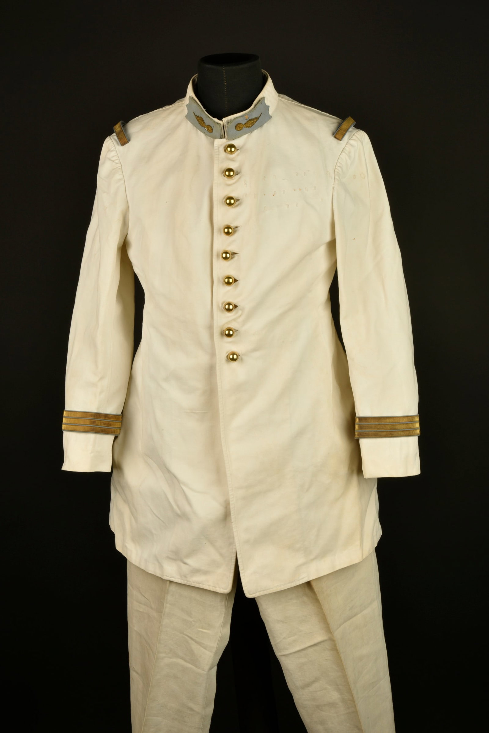 Ensemble capitaine tirailleurs. Tirailleur captain’s grouping.: Ensemble capitaine tirailleurs. Tunique en coton blanc se fermant par neuf boutons dores lisses, pattes de col amovibles bleu de ciel avec grenade d etat major brodee cannetille. Passants d epaule amo