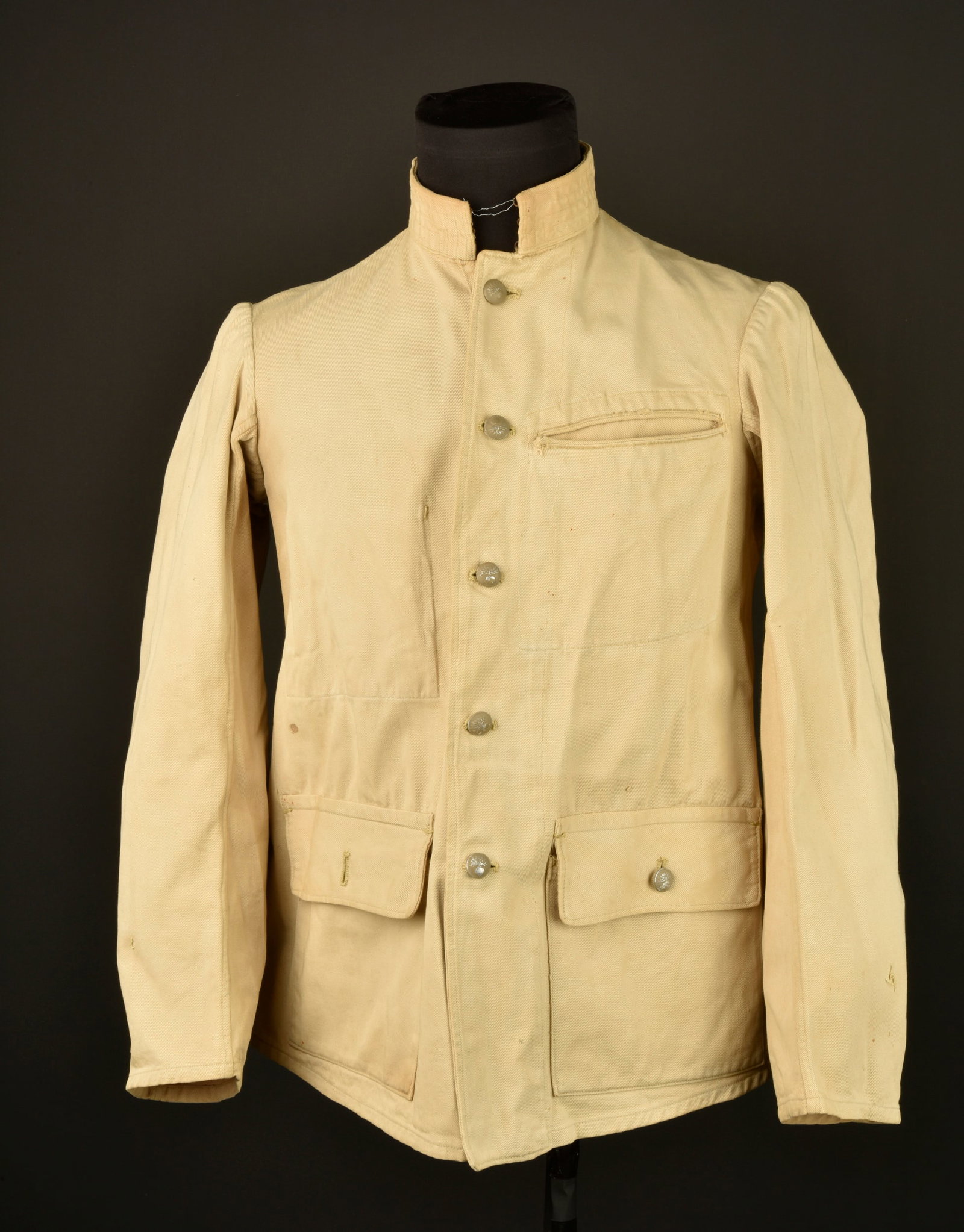 Vareuse en toile 1914-21. Canvas service tunic, 1914–1921 pattern.: Vareuse en toile 1914-21. Confectionnee en toile kaki claire et se fermant par cinq boutons aux armes de l infanterie en peinture kaki claire. Deux poches inferieures a rabat et une de poitrine sans r