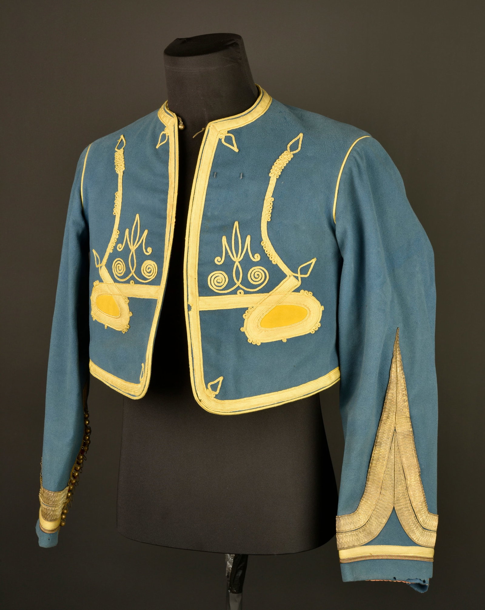 Bolero de tirailleur algerien. Algerian Tirailleur bolero jacket.: Bolero de tirailleur algerien. Confectionne en drap de laine bleu ciel, tresses, passepoil, motifs a l oriental et parements jonquille, la couleur du tombeau est egalement jonquille. Grades cousus aux