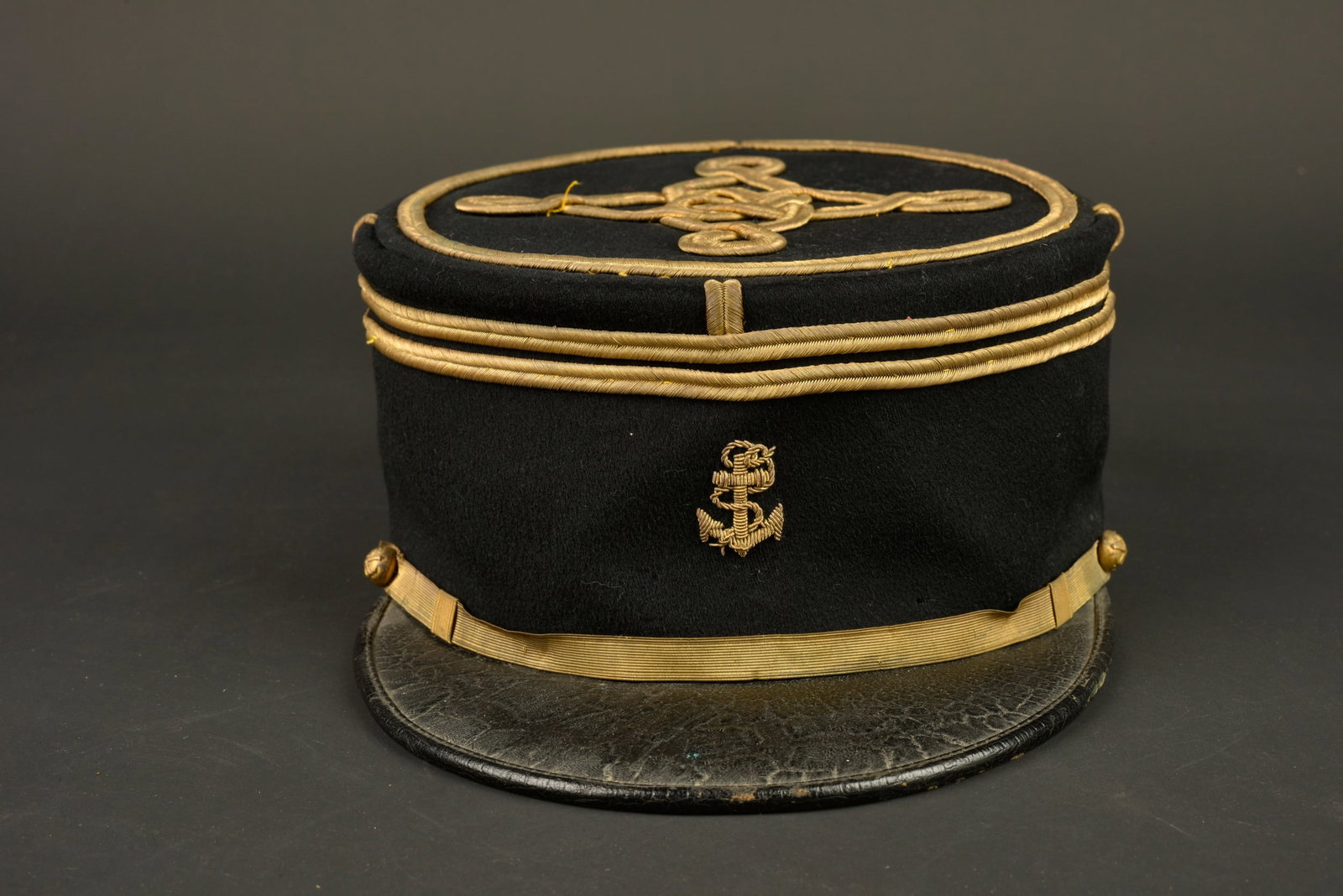 Kepi lieutenant artillerie coloniale. Colonial artillery lieutenant’s kepi.: Kepi lieutenant artillerie coloniale. Confectionne en drap noir, galons de lieutenant cousus d origine, ancre brodee cannetille. Fausse jugulaire doree retenue par deux boutons aux armes de l artiller