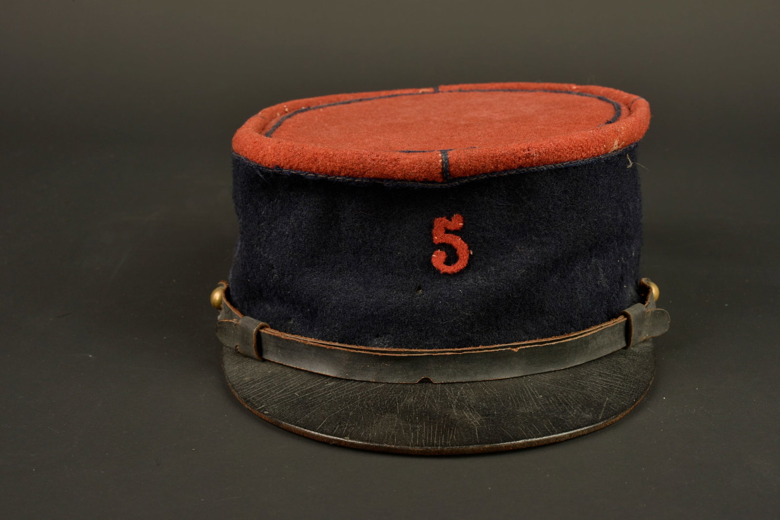 Kepi 1935 infanterie. 1935 Infantry kepi.: Kepi 1935 infanterie. Kepi modele 1935, plateau en drap garance, chiffre 5 en drap garance cousu a l avant du kepi correspondant au 5eme RI. Jugulaire en cuir du modele troupe retenue par deux petits 