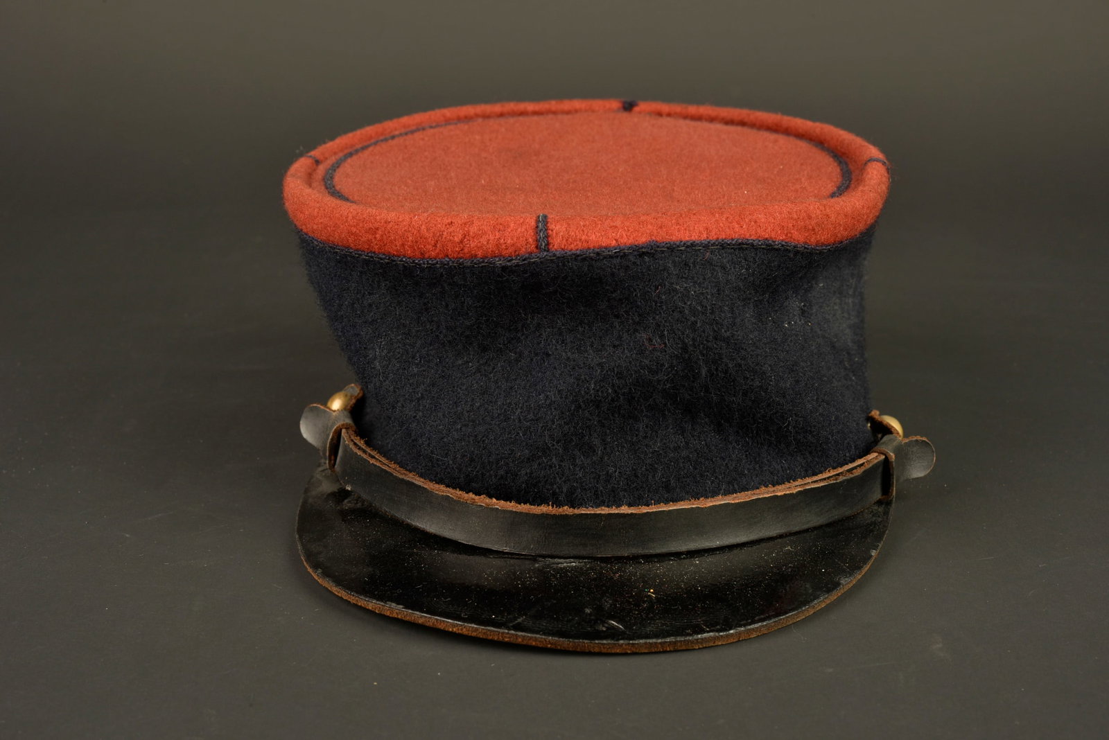 Kepi 1935 infanterie. 1935 Infantry kepi.: Kepi 1935 infanterie. Kepi modele 1935, plateau en drap garance, jugulaire en cuir du modele troupe retenue par deux petits boutons lisses dores. Visiere en cuir portant un cachet de controle, bandeau