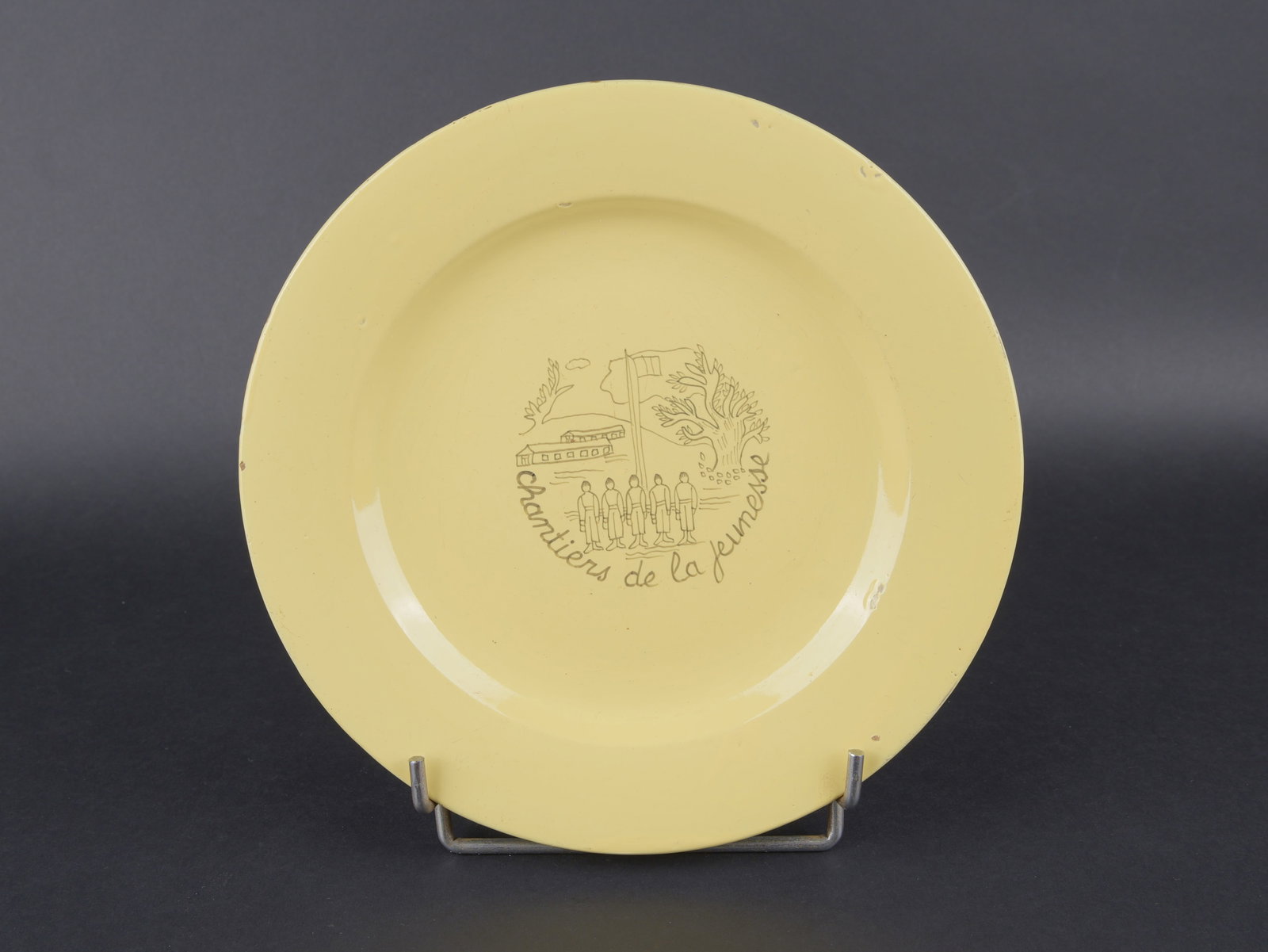 Assiette Chantier de Jeunesse. Youth Work Camps plate.: Assiette Chantier de Jeunesse. En ceramique jaune. Marquages Chantiers de la Jeunesse. Decors de caserne. Fabrication Henriot Quimper 101. Diametre 24,2 cm. A noter une certaine usure et patine de la