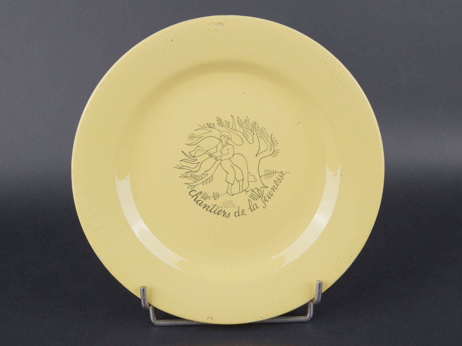 Assiette Chantier de Jeunesse. Youth Work Camps plate.: Assiette Chantier de Jeunesse. En ceramique jaune. Marquages Chantiers de la Jeunesse. Decors d un bucheron. Fabrication Henriot Quimper. Diametre 24,2 cm. A noter une certaine usure et patine de la