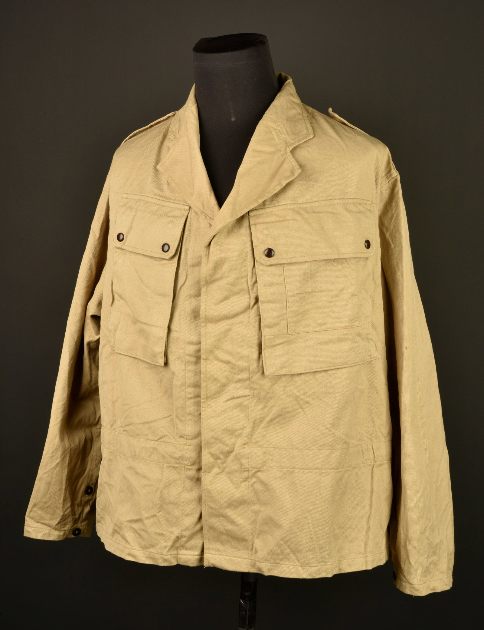 Veste de saut tropical. Tropical jump jacket.: Veste de saut tropical. Confectionnee en toile de coton beige, poche de poitrine se fermant a l aide de deux pressions en peinture marron d origine. Sous la poche de poitrine gauche se trouve une seco