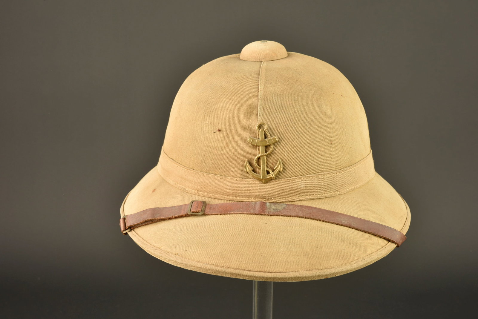 Casque colonial 1931. Model 1931 colonial helmet.: Casque colonial 1931. Casque modele 1931 confectionne en liege et recouvert d une toile en coton cachou pour l exterieur. Doublure en coton vert foret, ancre coloniale en laiton montee d origine.