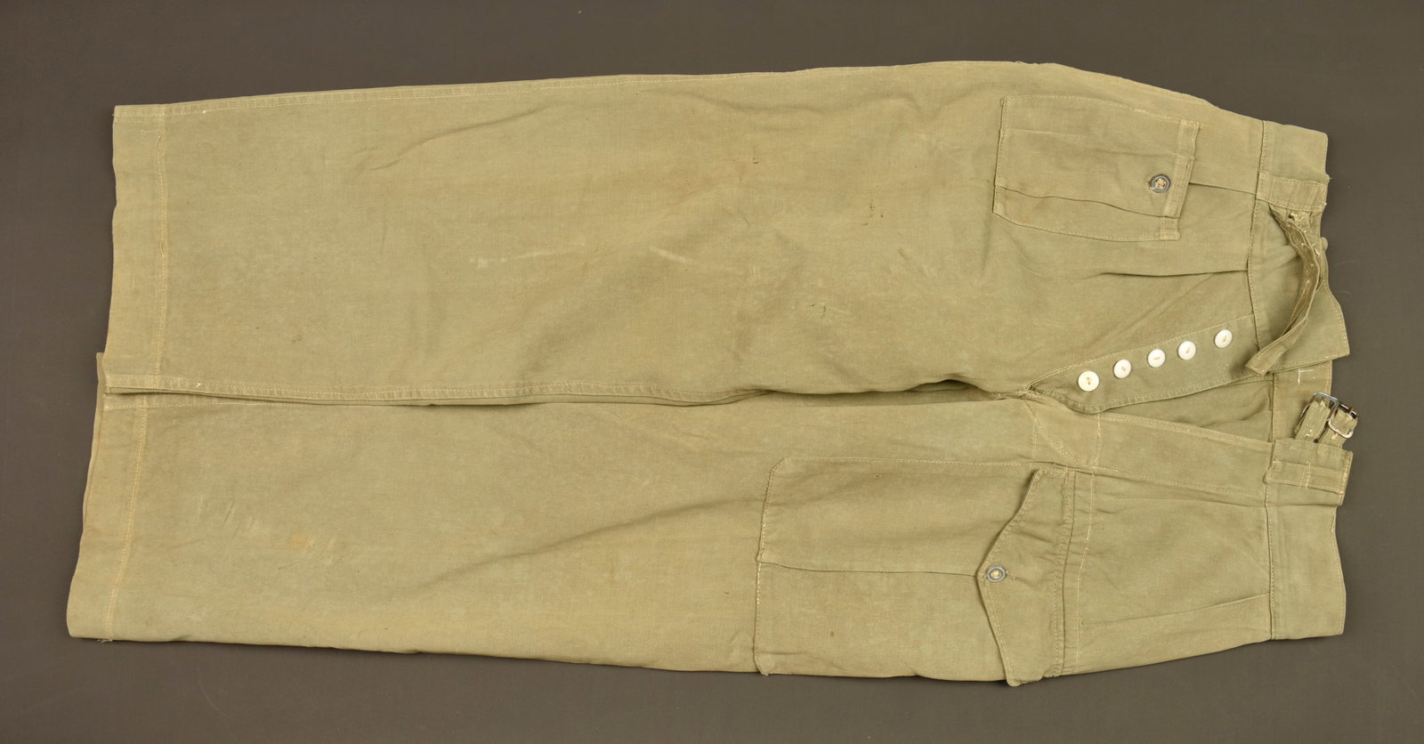Pantalon de jungle britannique. British jungle trousers.: Pantalon de jungle britannique. Confectionne en toile de coton kaki, se fermant par cinq boutons de braguette et une ceinture a deux passants de toile. Petite poche de hanche droite et large poche de 