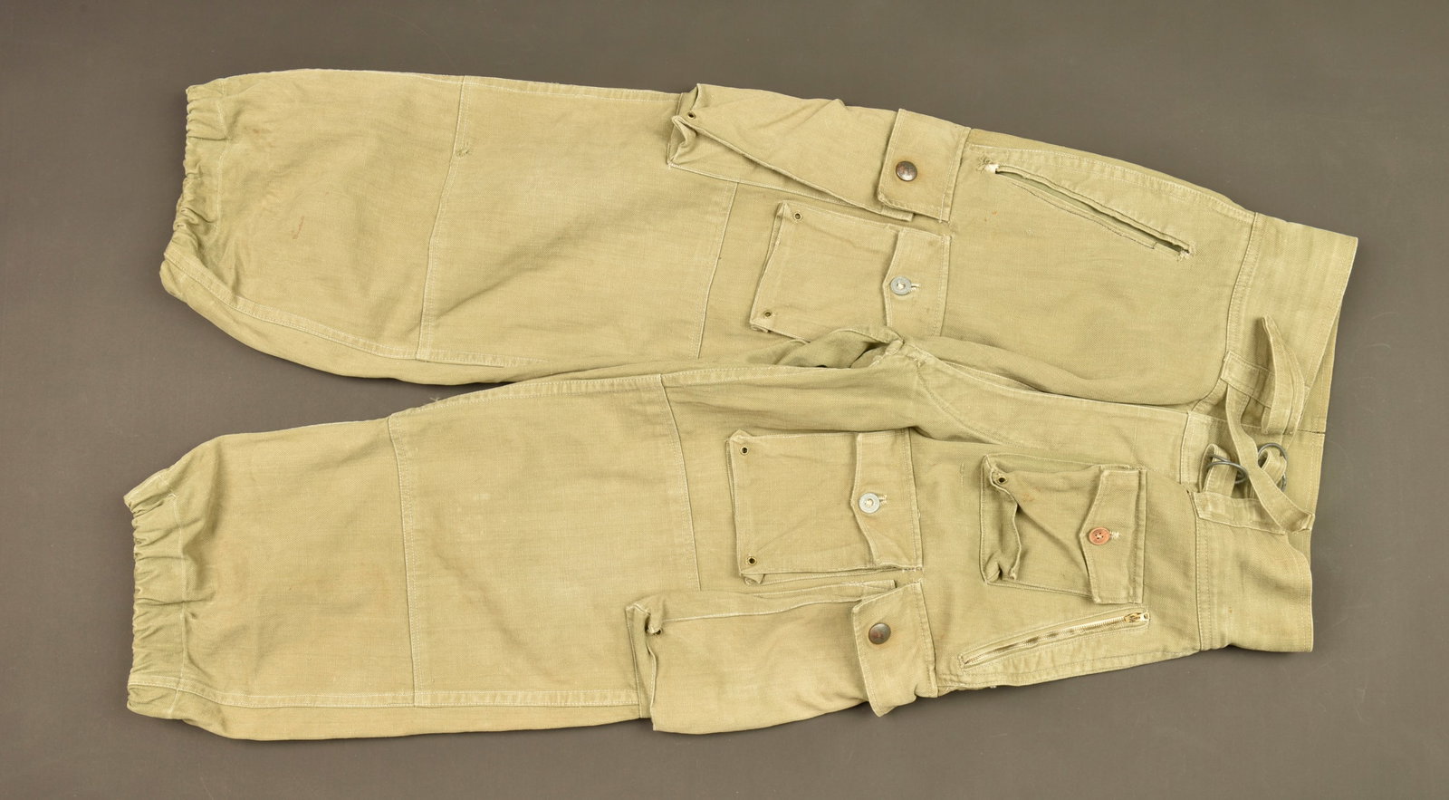 Pantalon de saut TAP Extreme Orient. Far East TAP jump trousers.: Pantalon de saut TAP Extreme Orient. Tenue de saut dite Chavatte, confectionne en fort tissu kaki, braguette se fermant par trois boutons, ceinture haute se serrant sur le devant par deux pattes de