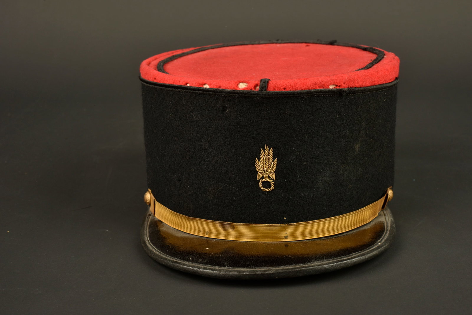 Kepi Legion infanterie. Foreign Legion infantry kepi.: Kepi Legion infanterie. Confectionne en drap ecarlate, bandeau en drap noir, passepoil au fil de coton noir. Grenade specifique a la Legion Etrangere brodee en cannetille doree a sept flammes. Fausse 