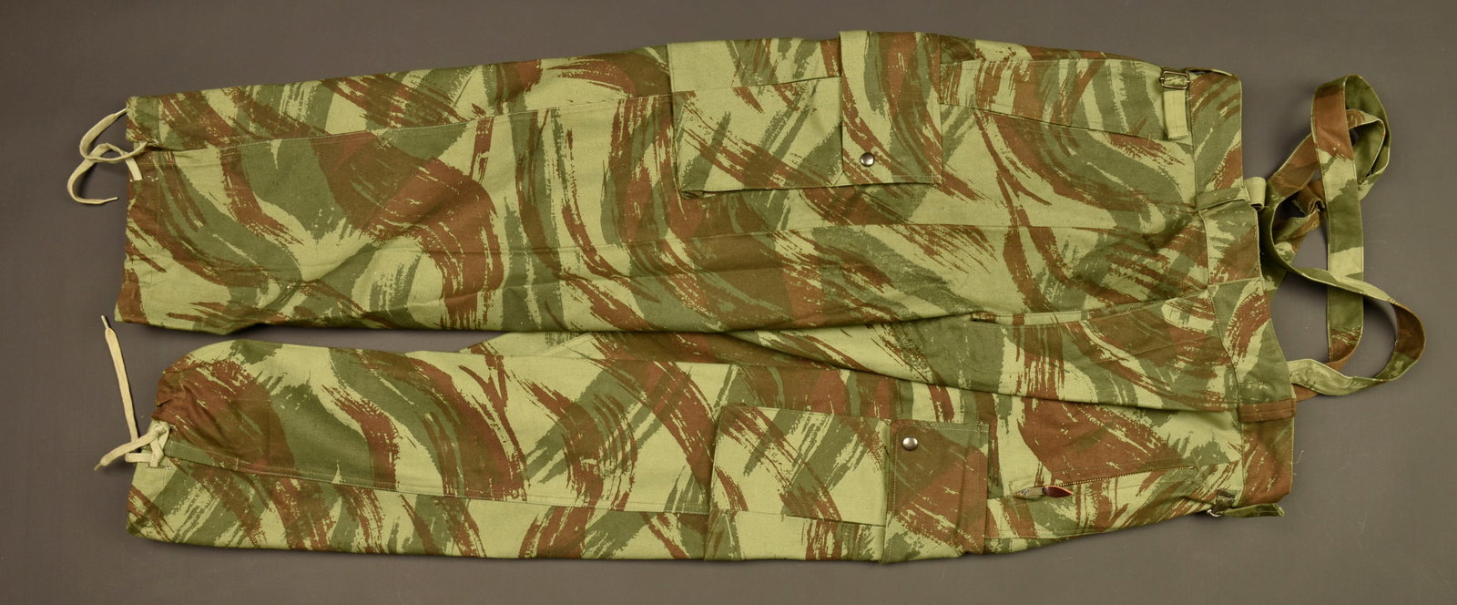Pantalon de saut TAP 47.53. TAP 47/53 jump trousers.: Pantalon de saut TAP 47.53. Confectionne en tissu camoufle 47.53, les pressions sont bronzees, pattes de serrage aux hanches, poche de hanche gauche se fermant par une fermeture eclaire de marque Aile