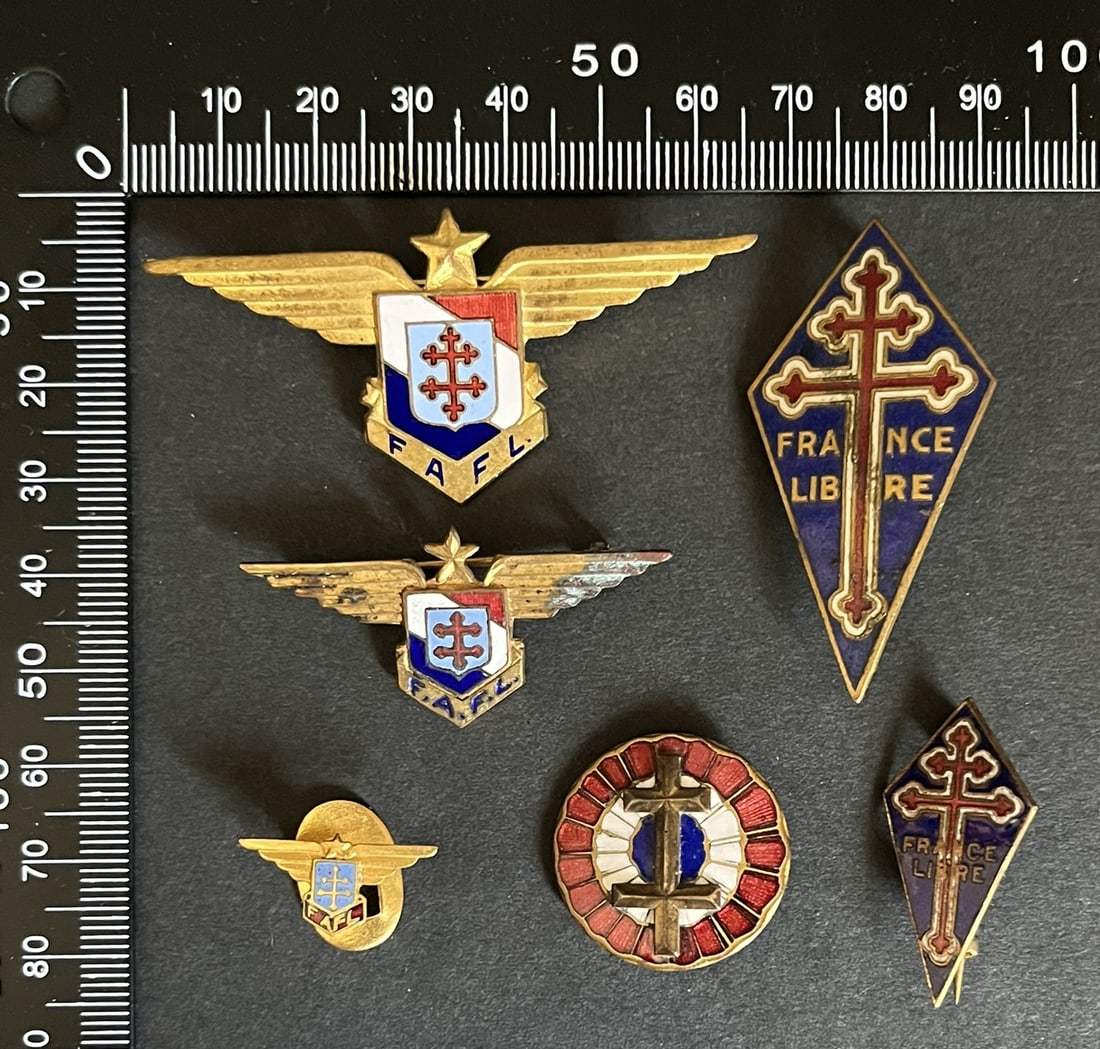 FRANCE LIBRE INSIGNES. Free France insignia: Lot de 6 pieces insigne FAFL 65 x 30 mm numerote 7360 fabrication anglaise Sans emaille un autre demie taille pour chemise ou calot 45 x 22 mm fabrication anglaise emaillee (oxydations) insigne FNFL 5