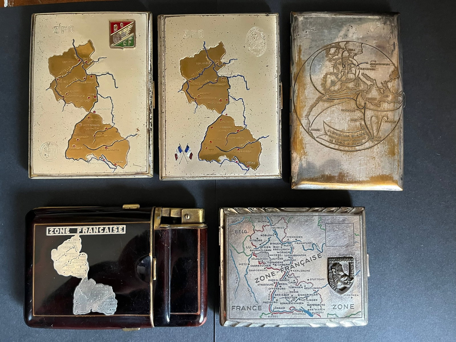 FRANCE LIBERATION FFA PORTE CIGARETTES. France Liberation FFA cigarette case: Lot de 5 pieces Porte cigarette ZFO avec insigne grave Resistance Fer un autre ZFO et insigne rapporte Direction Ouest des Chemins de Fer un autre portant l itineraire de la 2 DB 1940 a 1945 un autre 