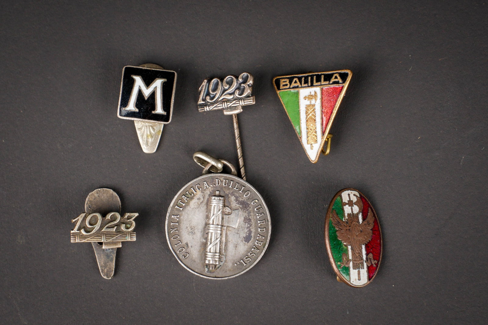 Insignes italien. Italian insignia.: Lot de 6 insignes fascistes comprenant une epinglette 1923 et la meme avec attache demi-lune, les deux pour des campagnes fascistes, un insigne de Ballila du premier modele, un M pour Mussolini, un in