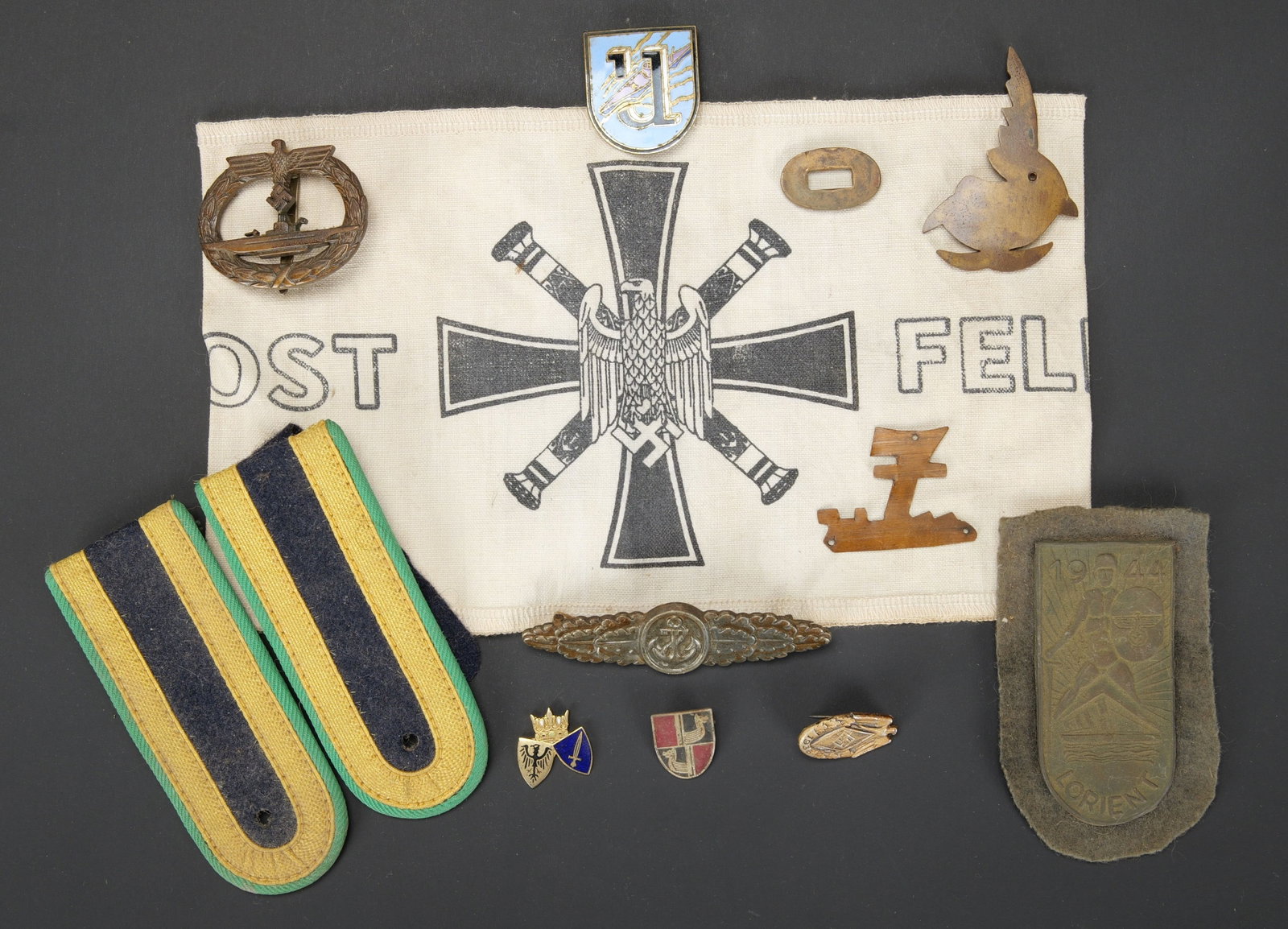 Reproduction d insignes de la Kriegsmarine. Reproduction Kriegsmarine insignia.: Reproduction d insignes de la Kriegsmarine. Comprenant trois insignes de coiffures de la Kriegsmarine. UN brevet de sous-marinier. Une plaque Lorient. Une paire de pattes d epaule DDR. Une spange