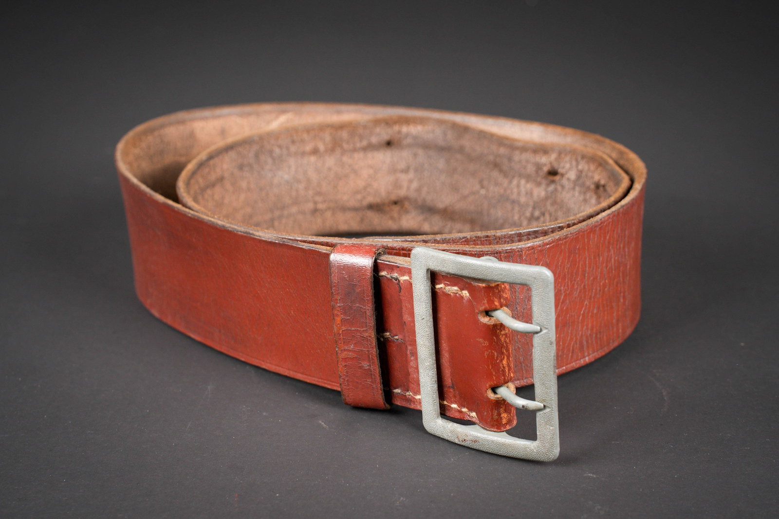 Ceinturon d officier allemand. German officer?s belt.: Ceinturon d officier allemand. En cuir marron. Boucle en metal grenele a deux ardillons. Les passants sont manquants. Sans marquages visibles. Taille illisible. A noter une certaine usure et patine