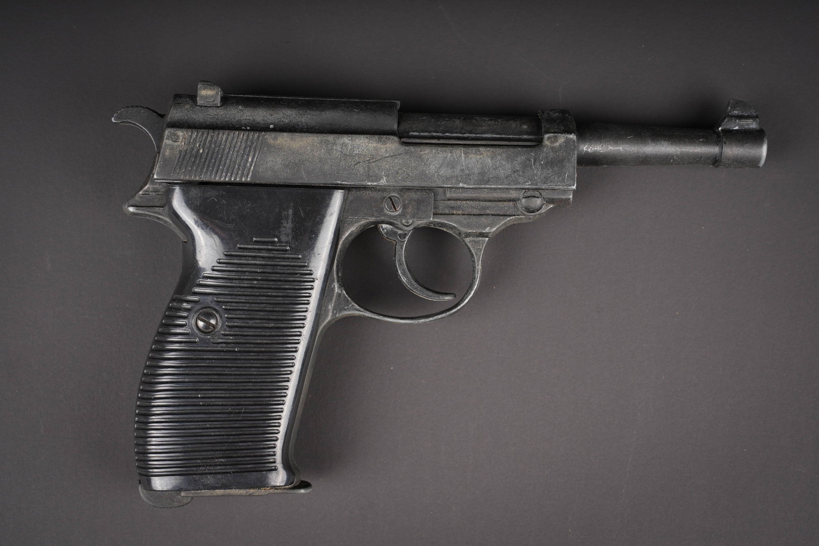 Replique de pistolet automatique allemand P38. Replica of a German P38 semi-automatic pistol.: Replique de pistolet automatique allemand P38. Replique de P38, en alliage et materiaux de synthese. Pas de marquage visible. Quasi-arme inapte au tir. Usure d usage, patine. Replica of a German P38