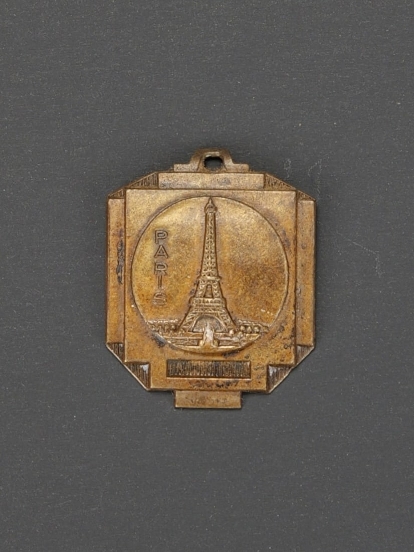 Plaquette occupation de Paris. Plaque of the Occupation of Paris.: Medaillette occupation de Paris. En metal, decor de la Tour Eiffel. Marquages au dos Besetzung von Paris 14 juni 1940. Medaillette destine a etre pendue a la chaine d un porte cle. Attache absente. A