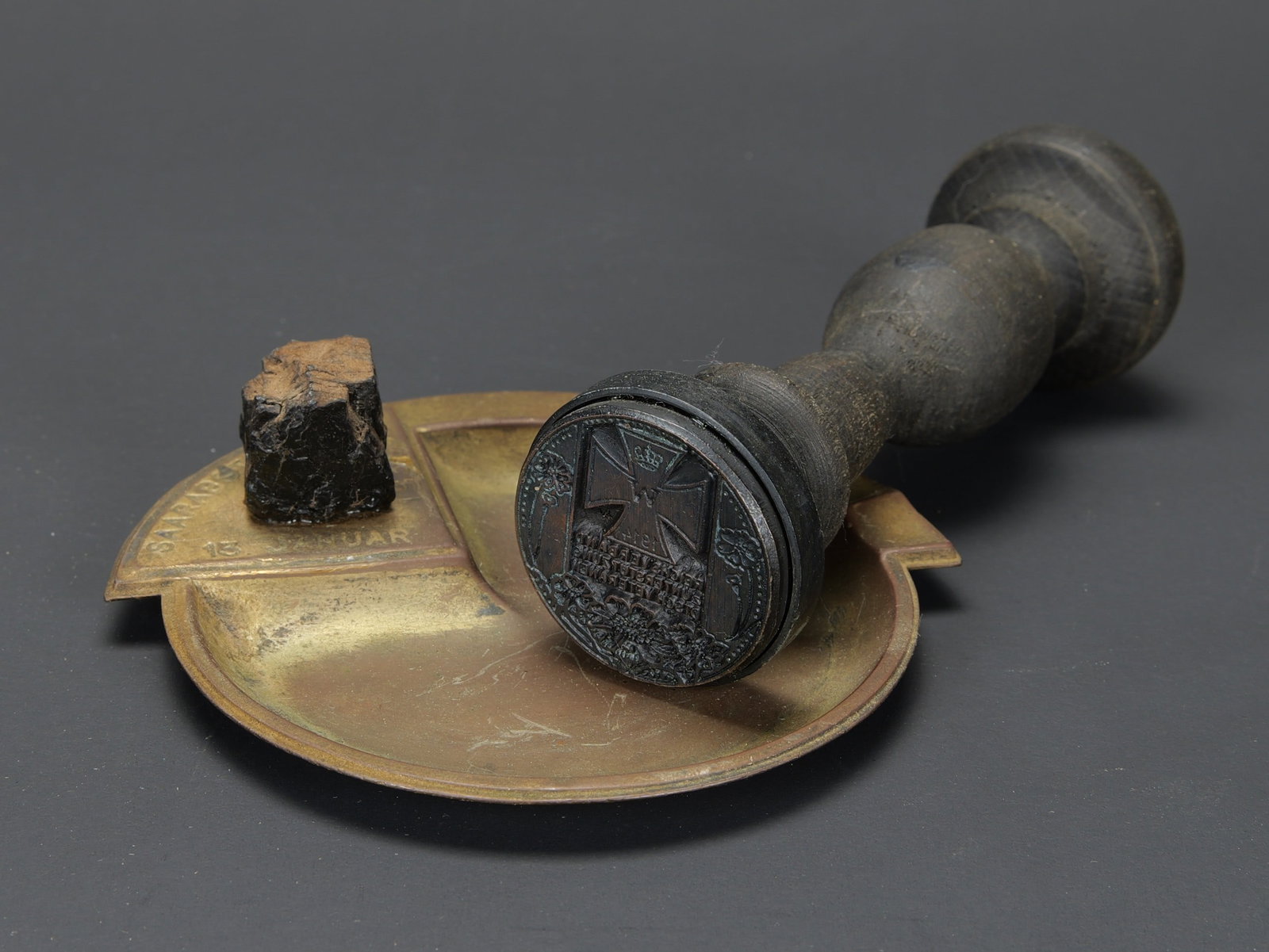 Accessoires allemand. German accessories.: Accessoires allemand. Comprenant un cendrier en laiton incomplet, marque Saarabstimmung 15 januar 1935. Un tampon allemand de la premiere guerre mondiale, en bois, marquages avec croix de fer. A