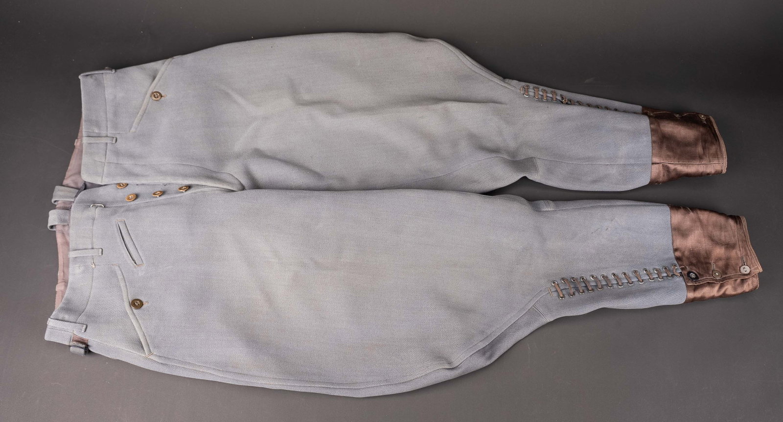 Pantalon culotte de cheval d officier allemand. German officer Breeches.: Pantalon culotte de cheval d officier allemand. En gabardine grise. Bas des jambes fermant par une rangee de trois boutons et un lacage a 13 ?illets. Interieur double en tissu coton blanc et bleu.
