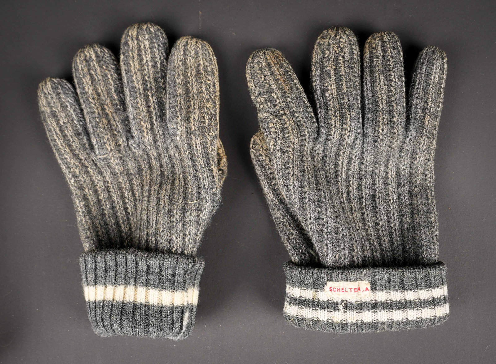 Gants allemand. German gloves.: Gants allemand. Belle paire de gants en laine grise. Paire non homogene dans la fabrication. Un gant dispose d une seule bande blanche, le second de deux bandes blanches. Indication nominative A