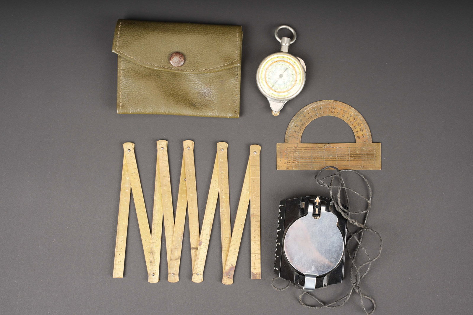 Accessoires de porte carte allemand.: Accessoires de porte carte allemand. Comprenant une pochette en toile impermeabilise Feldgrau, bouton pression fonctionnel. Sans marquages visibles. Un rapporteur en metal. Une boussole en bakelite,