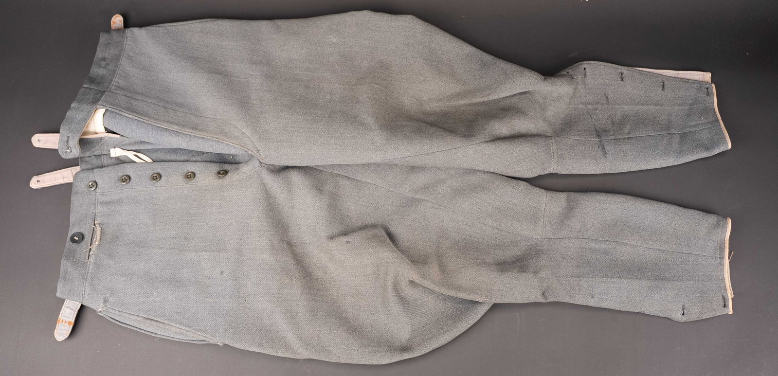 Pantalon culotte de cheval officier allemand. German officer Breeches.: Pantalon culotte de cheval d officier allemand. En gabardine grise. Bas des jambes fermant par une rangee de cinq boutons. Certains boutons sont manquants. Interieur double en tissu coton blanc. Sans