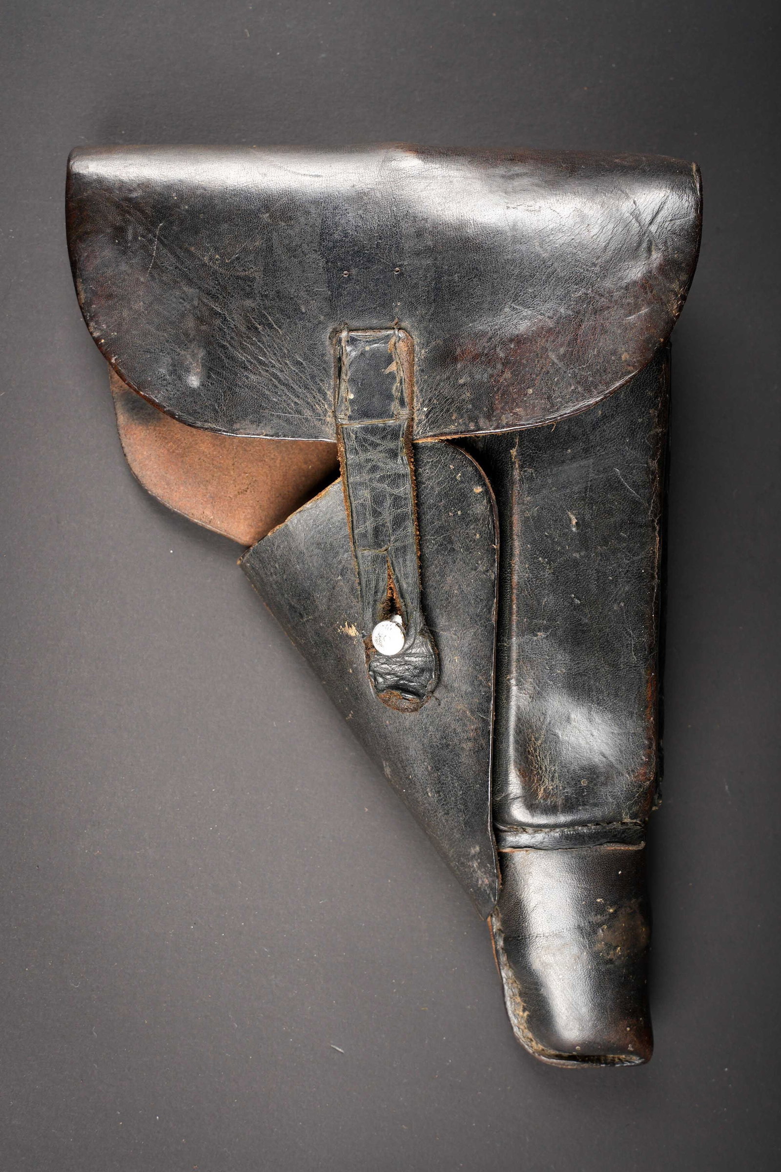 Holster de pistolet P38. German P38 holster.: Holster de pistolet P38. En epais cuir noir. La sangle de fermeture a ete replacee et reparee. Les passants au dos sont presents. Reste de marquages P38 au dos, ainsi qu un autre marquage WAA, date 19